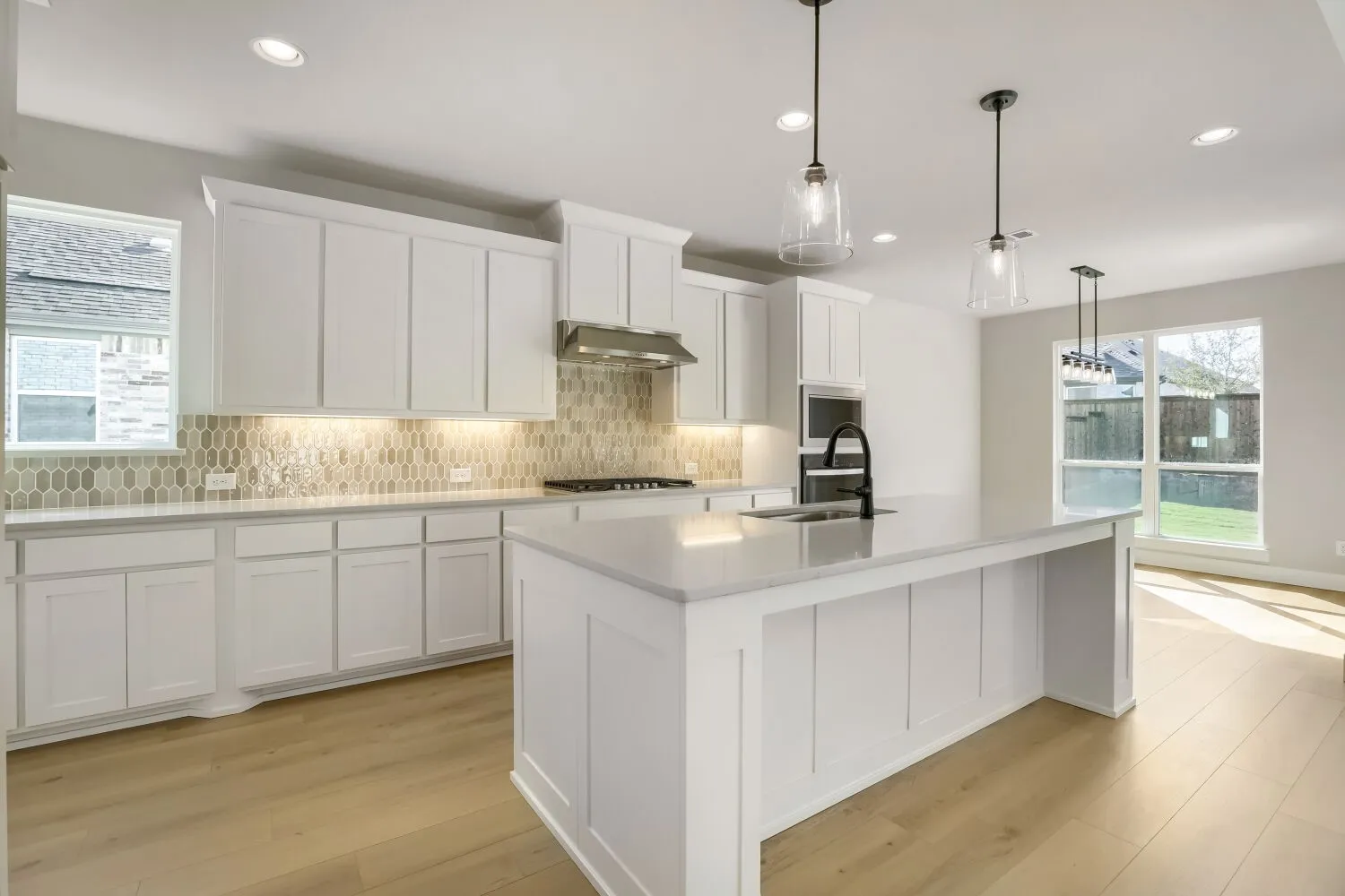 Kitchen featuring white cabinetry, light-toned wood-finish flooring, recessed lighting, and a kitchen island with pendant lighting
