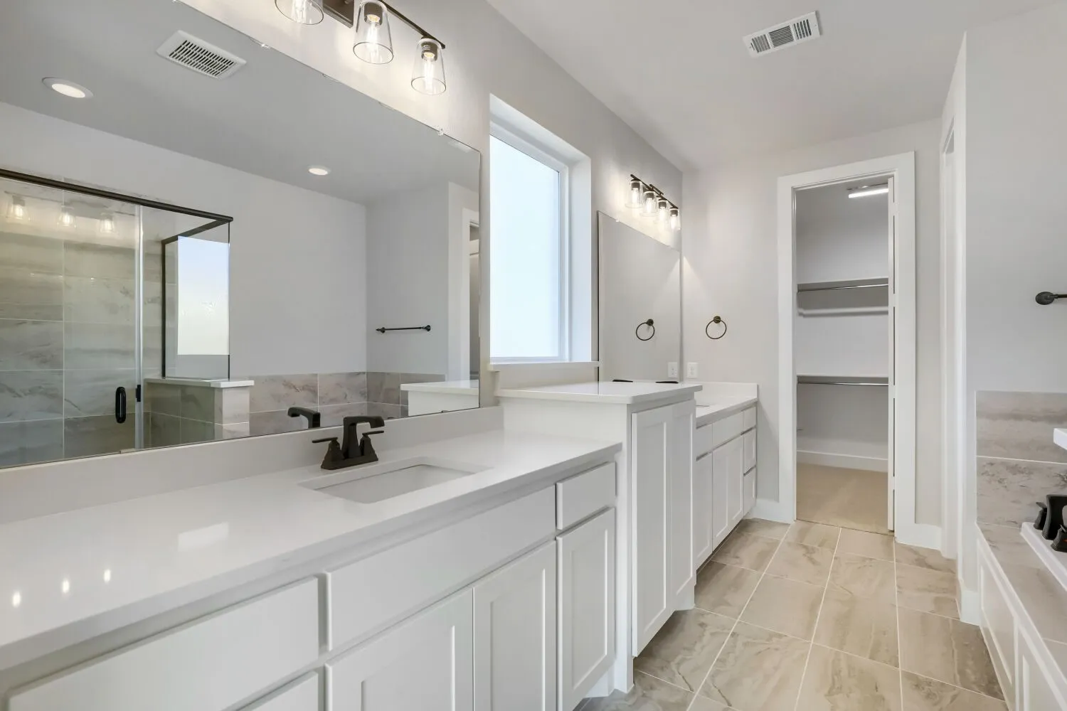 Dual vanities with white cabinetry and integrated sinks