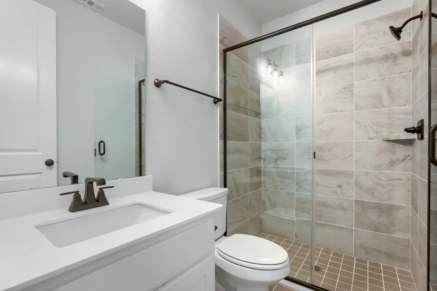 White vanity with integrated sink, bronze-finish faucet, and coordinating hardware