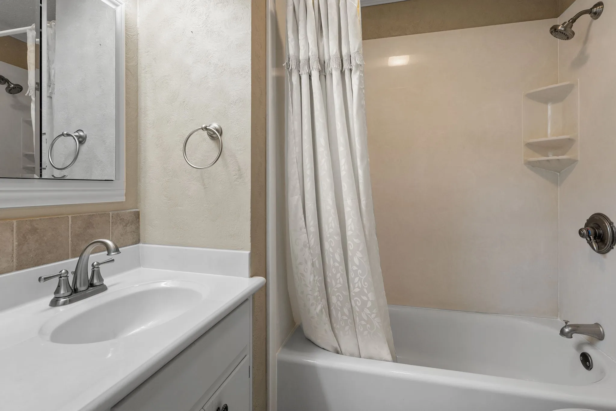 Bathroom featuring a white vanity with an integrated sink, brushed nickel faucet, and coordinating towel ring