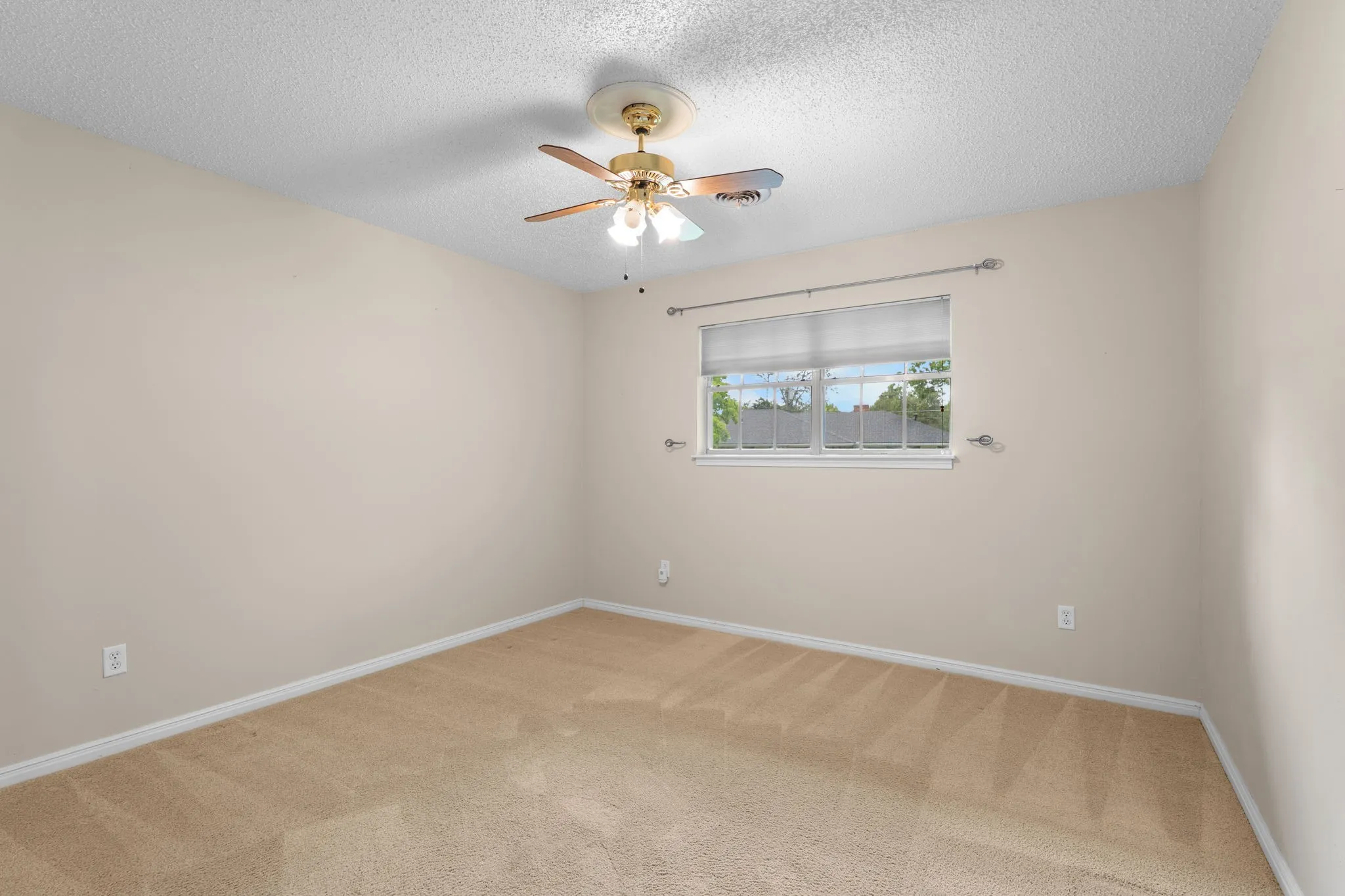 Bedroom featuring neutral-toned carpet flooring, light-colored walls, a ceiling fan with integrated lighting, and a window with blinds