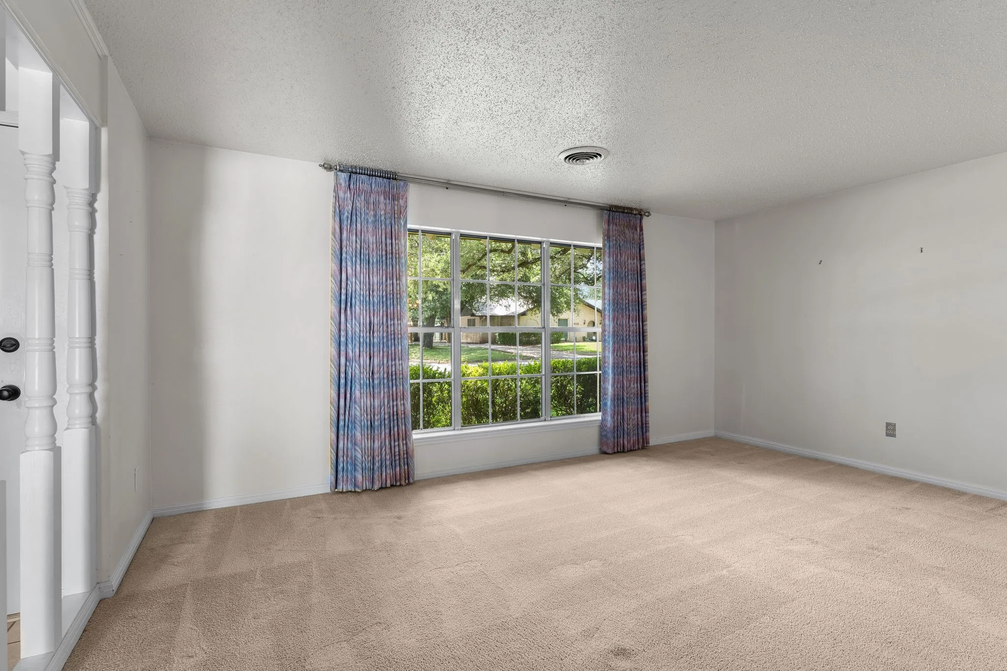 Spacious room featuring neutral carpeting and white walls