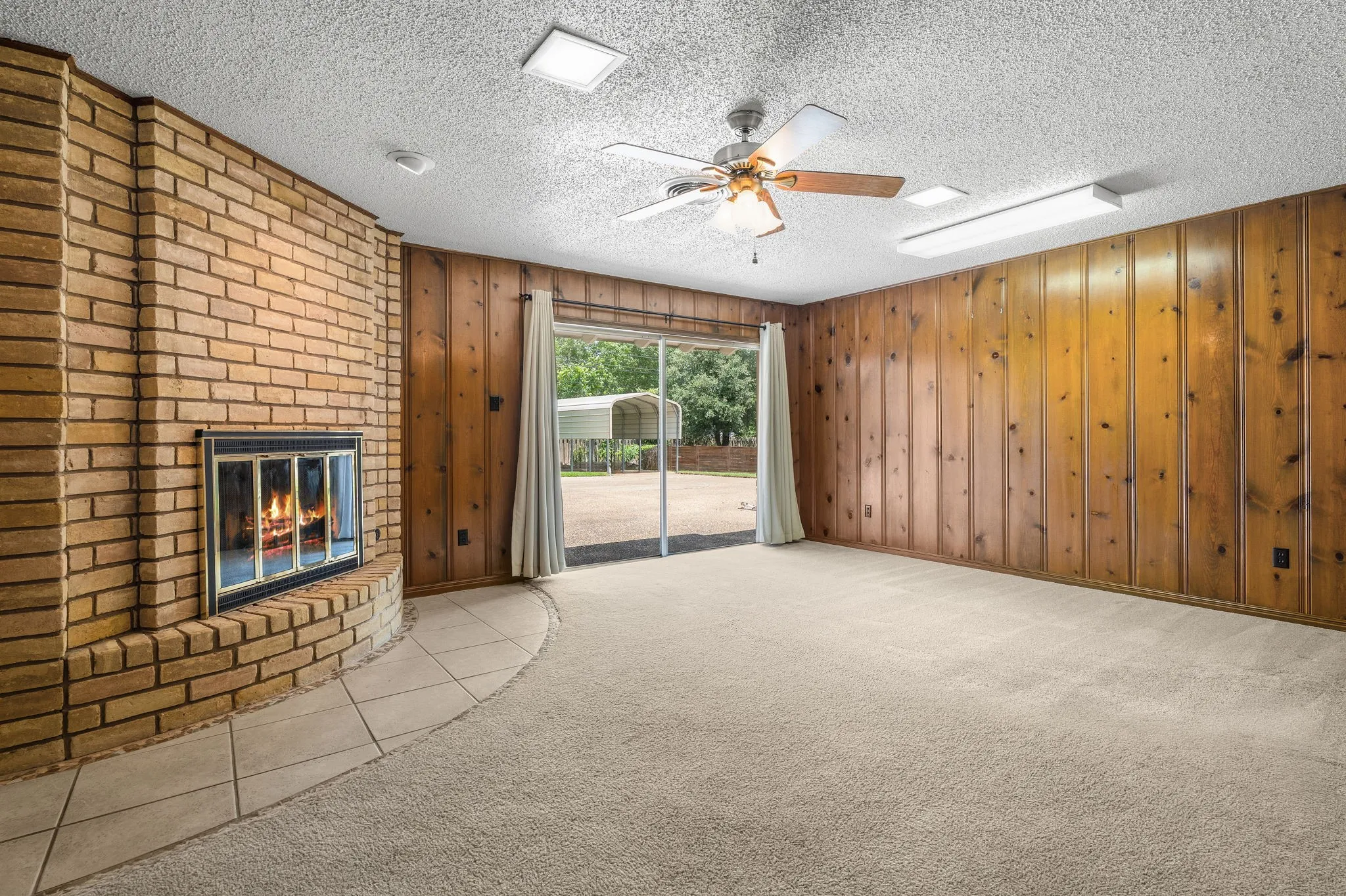 Brick fireplace with a glass-front insert and tile hearth