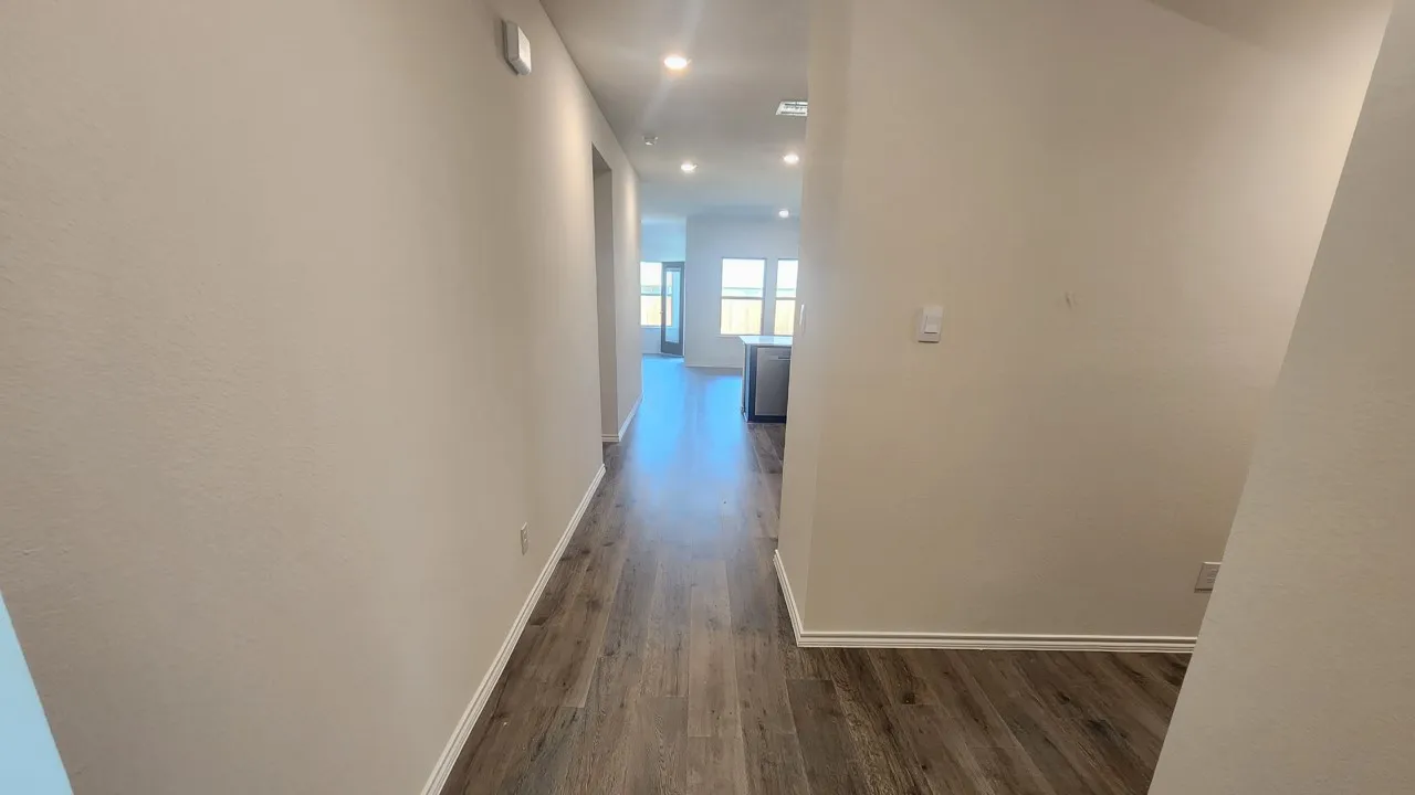 Hallway featuring wood-finish flooring, recessed lighting, and a neutral wall palette