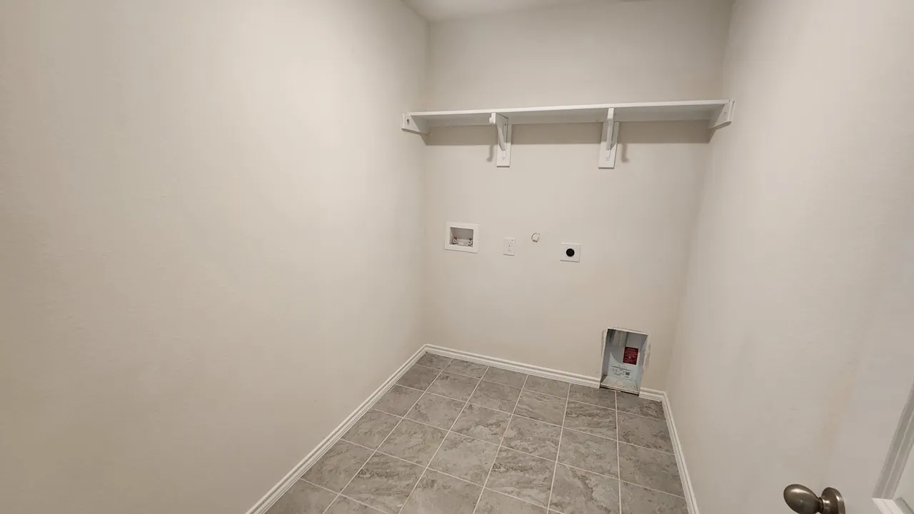 Dedicated utility space featuring tile flooring and built-in shelving