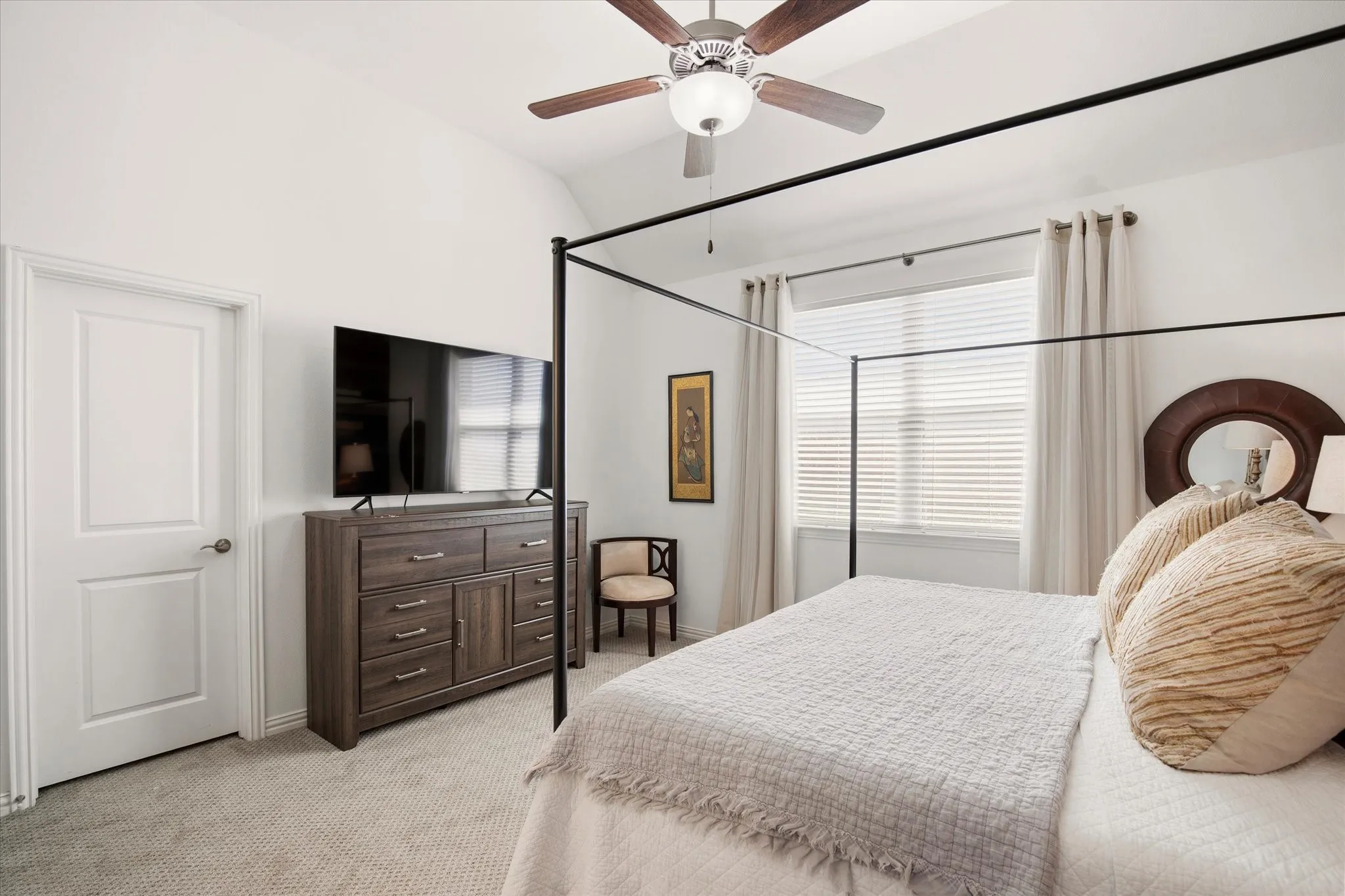 There is a large window flooding natural light into the primary bedroom.