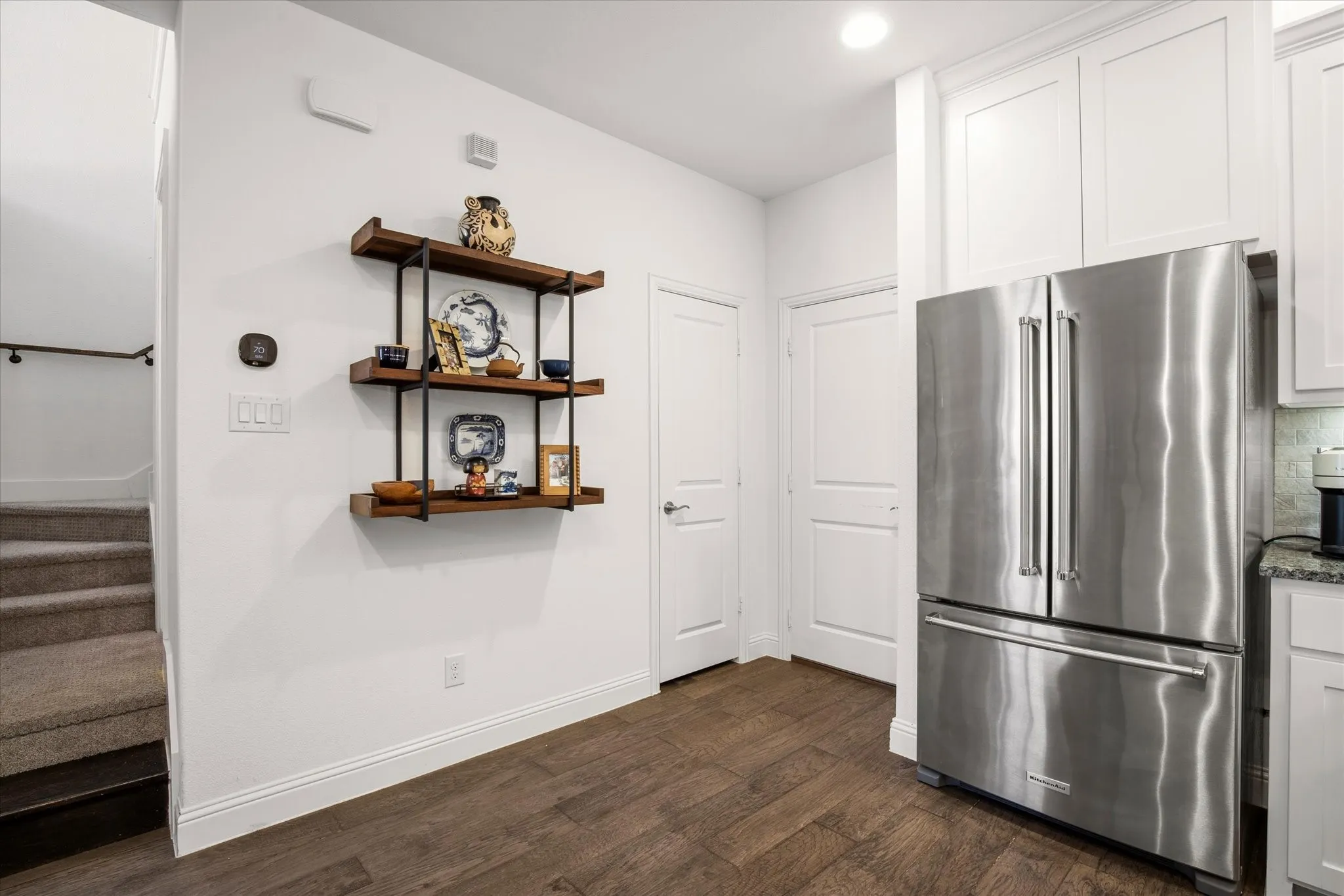 From the kitchen, there is an exit to the garage or a landing to the powder bath.