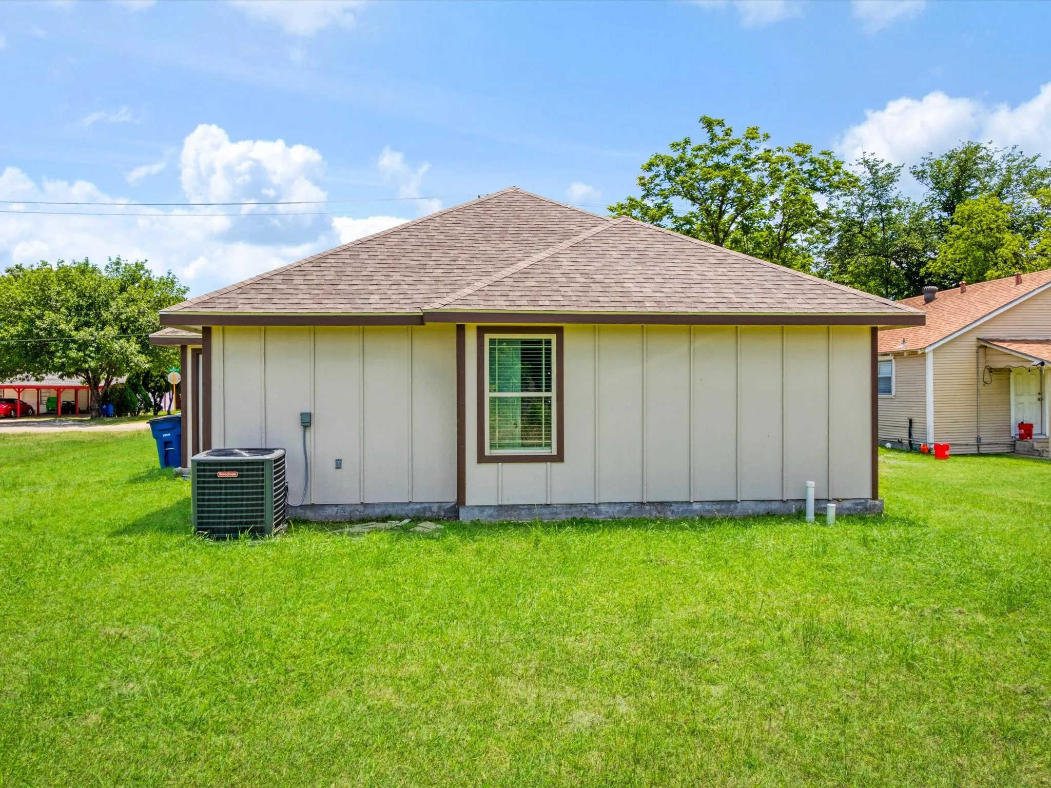 Exterior features a light-colored siding, brown trim, and a brown shingle roof