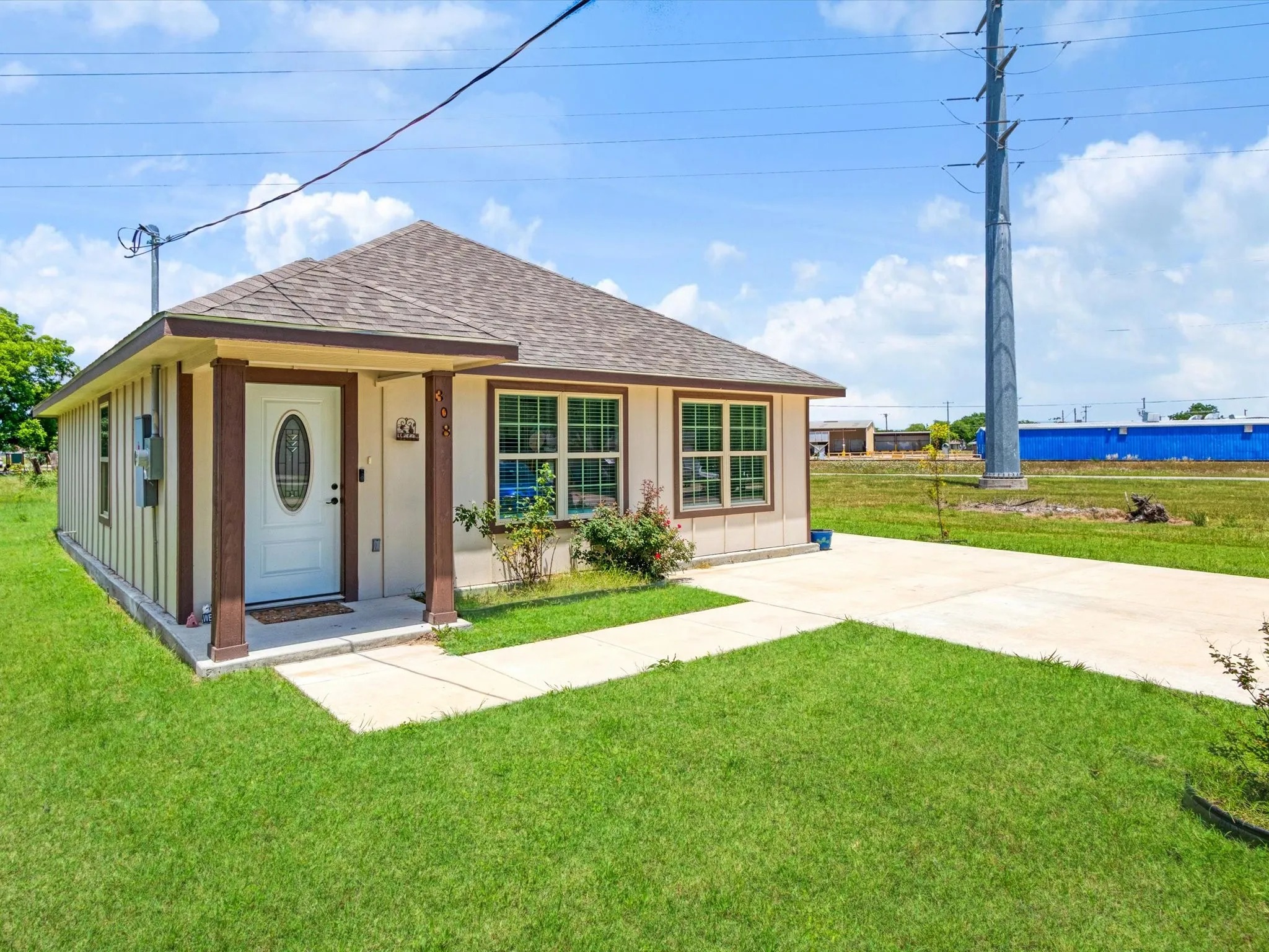 Single-story residence featuring a covered front porch with decorative columns, a concrete walkway, and a concrete driveway