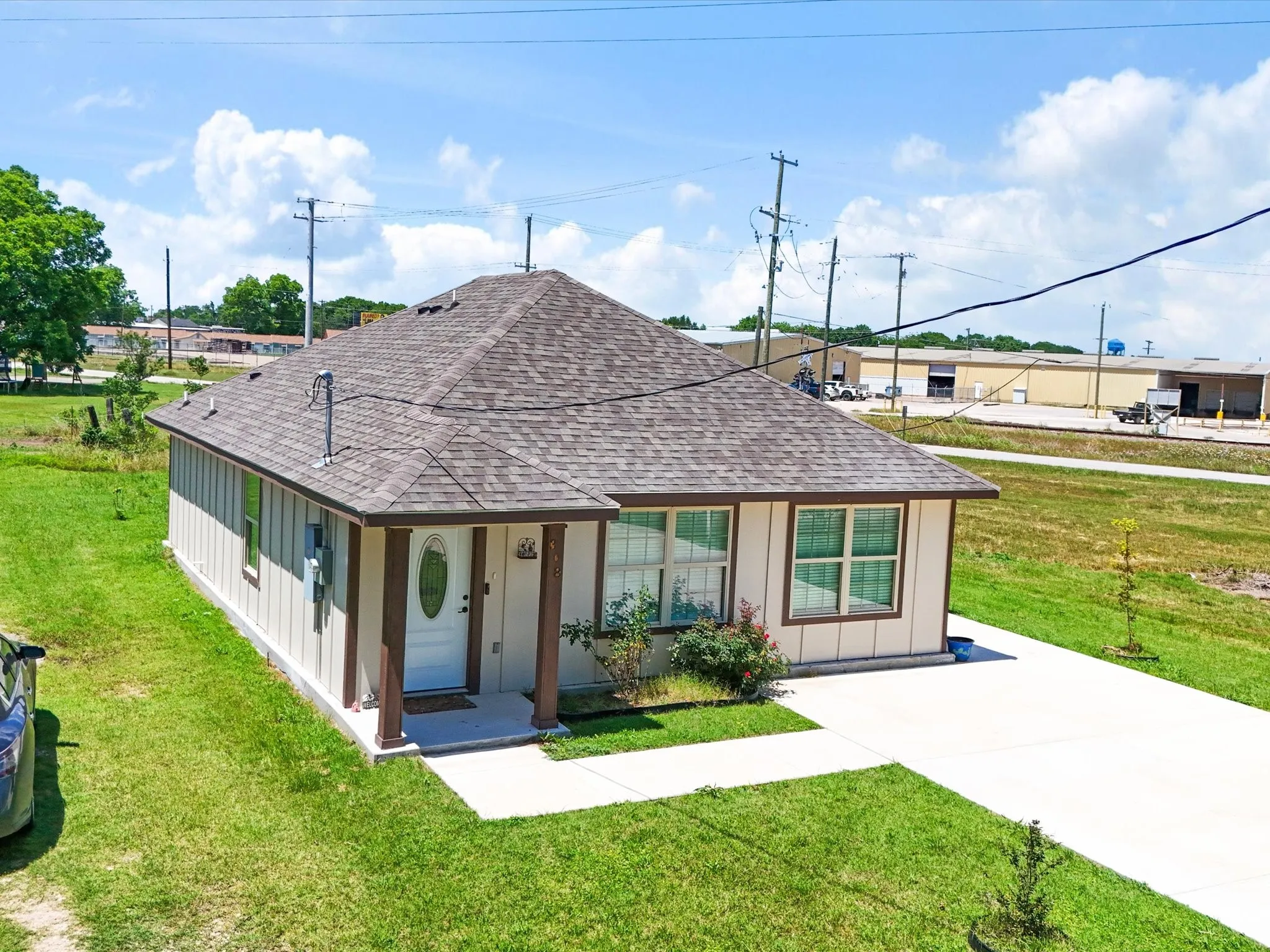 Single-story residence featuring a gabled roof and light-colored siding with dark trim