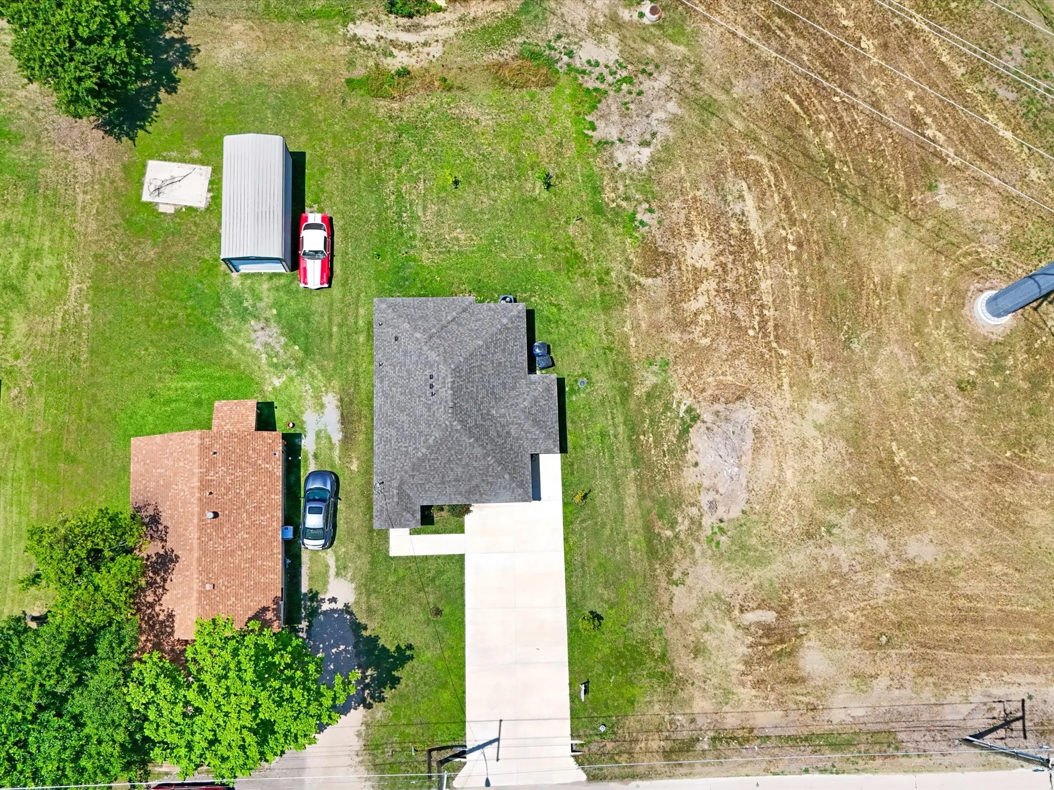 Aerial view showcasing the property with a detached storage shed and expansive surrounding land
