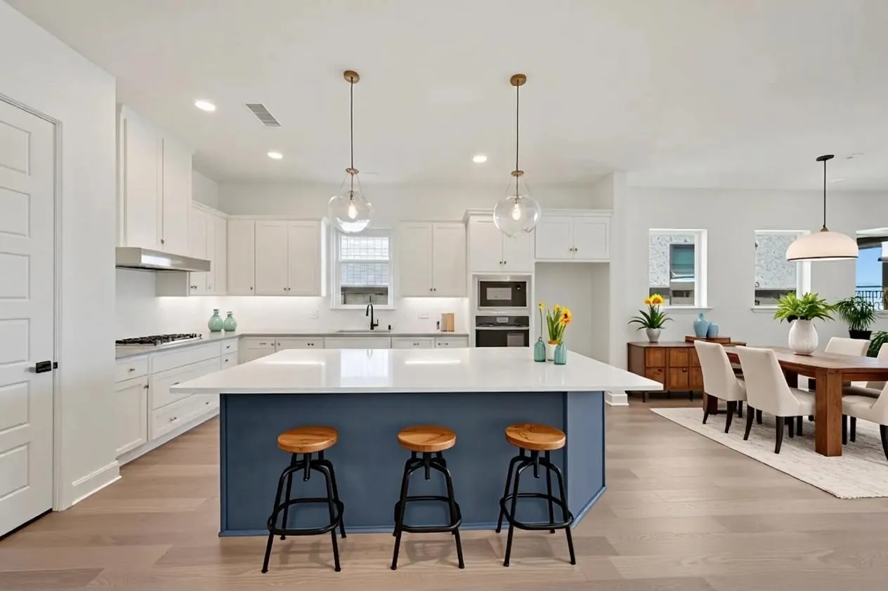 Open-concept kitchen featuring white cabinetry, a blue kitchen island with a white countertop, stainless steel appliances, and wood-finish flooring