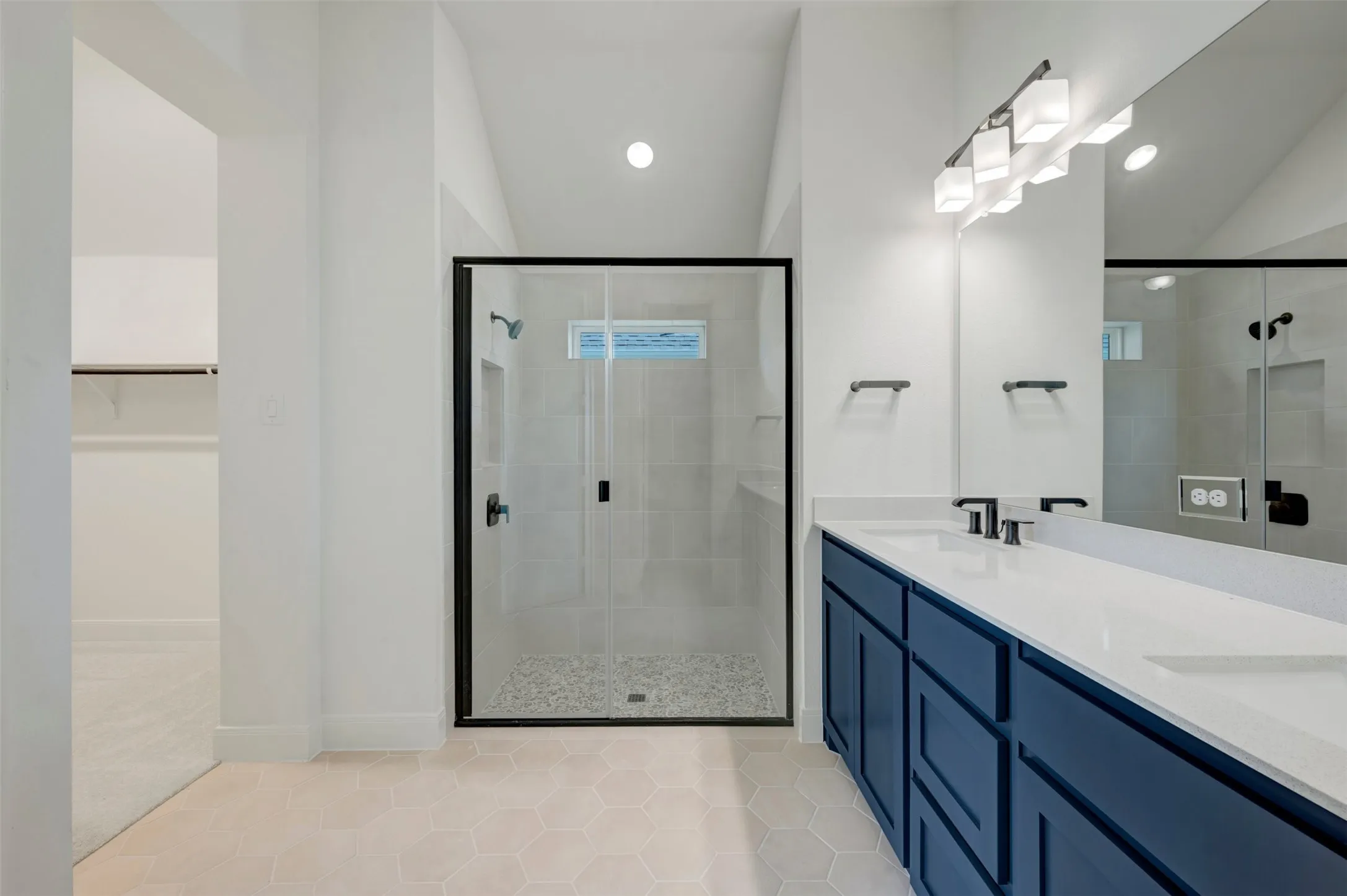 Dual vanity with white countertops, dark blue cabinetry, and matte black fixtures