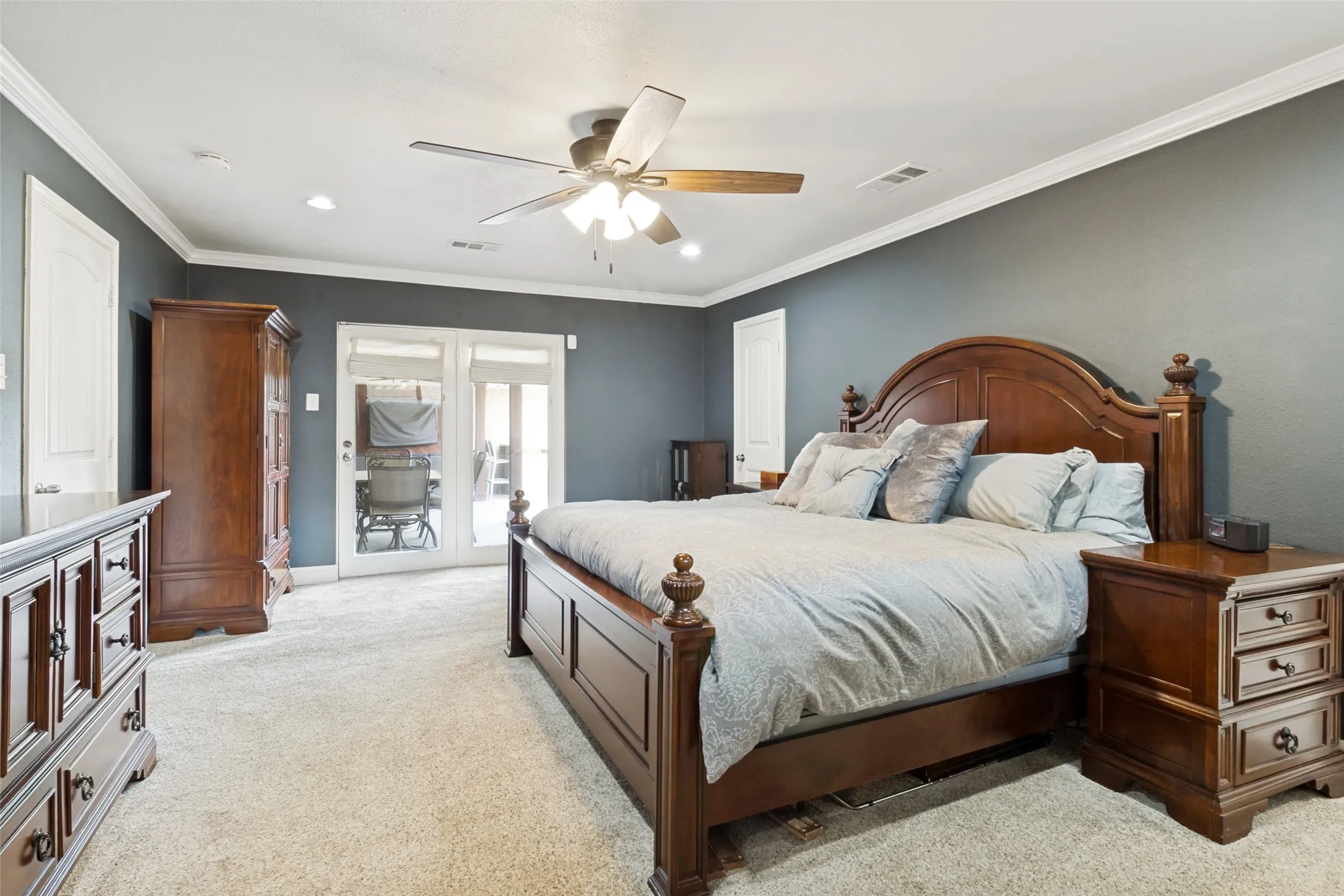 Spacious primary suite has doors that lead to the pool and patio, remodeled ensuite bath.