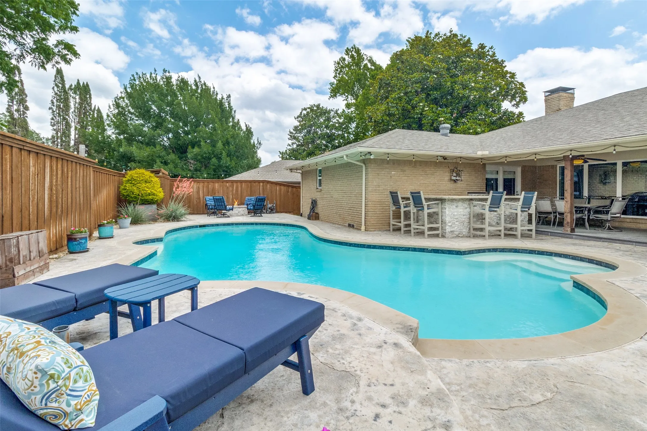 Welcome to your backyard oasis with sparkling pool, fire pit, putting green, built in grill and covered patio.