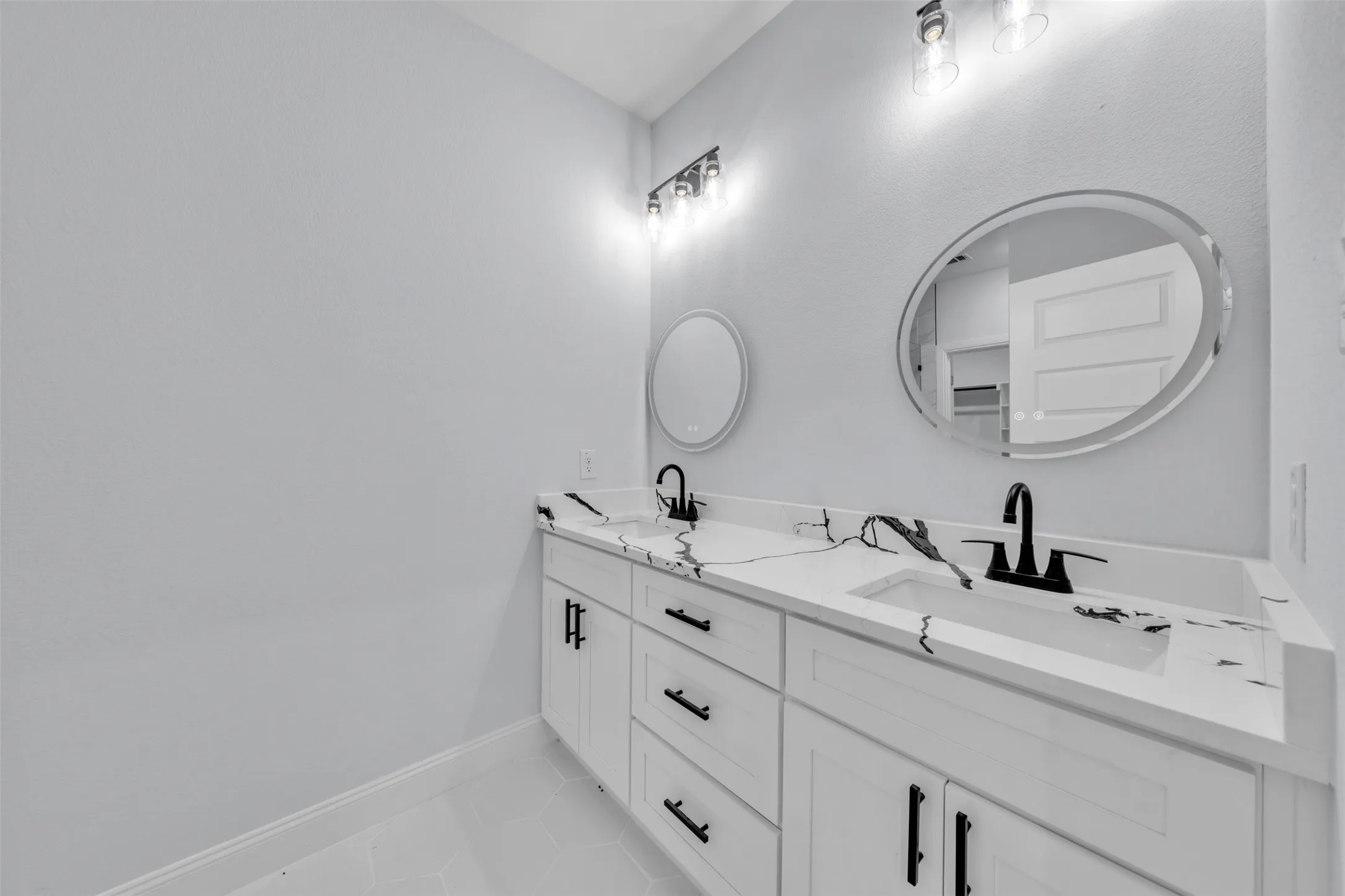 Dual vanity with white cabinetry and black hardware