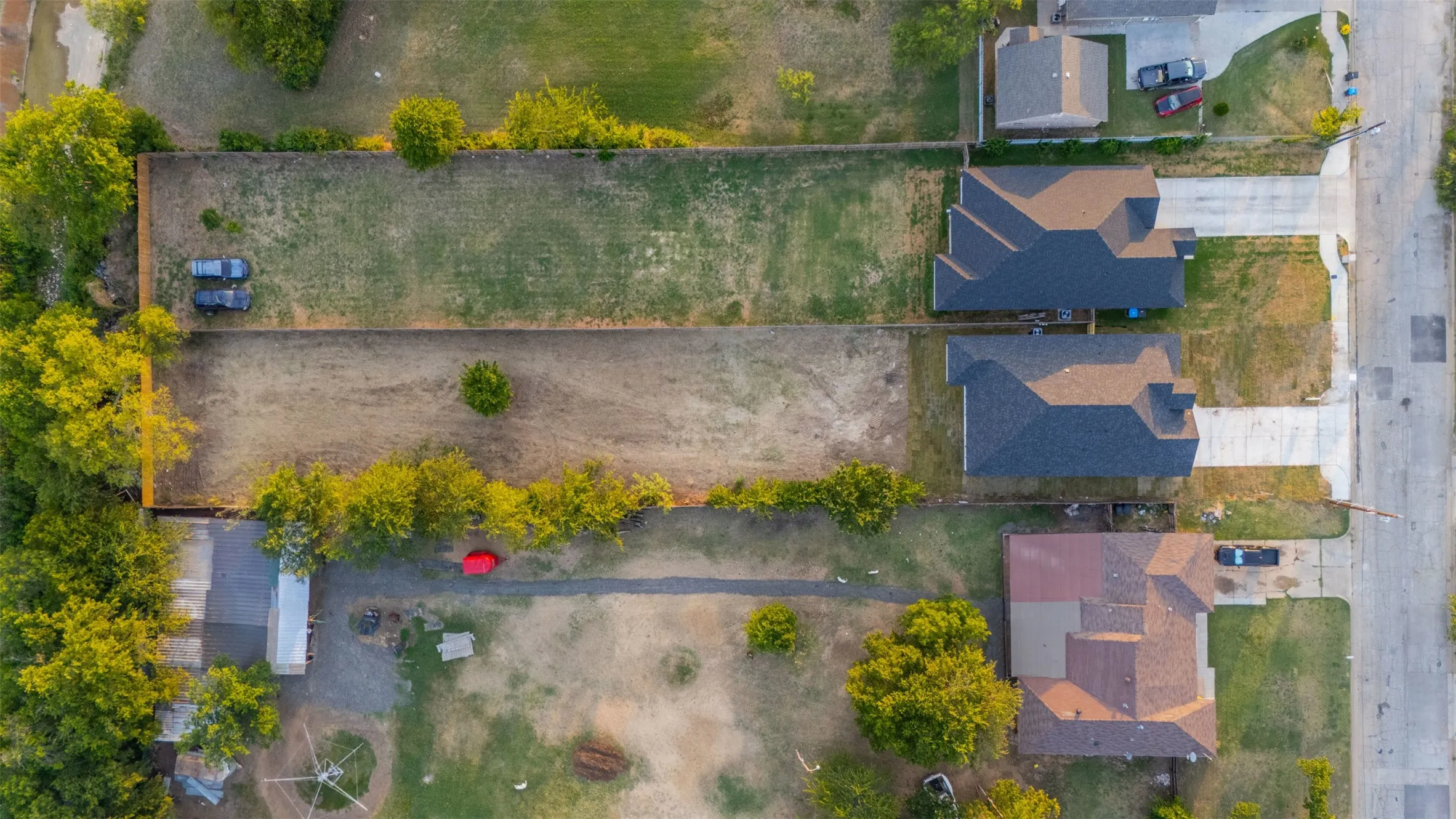 Expansive land parcel featuring a rectangular shape, natural ground cover, and mature perimeter trees