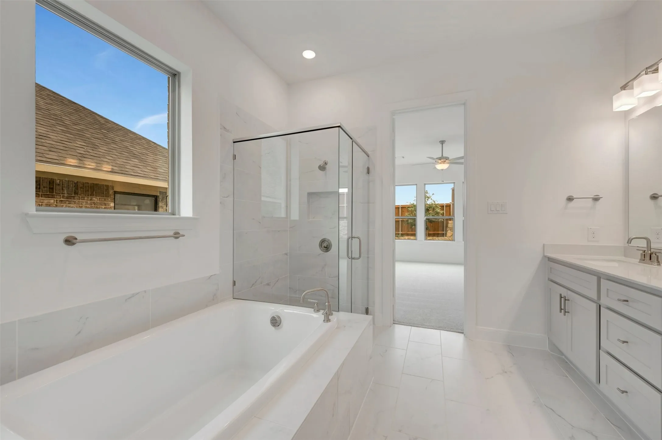 Contemporary bathroom featuring a built-in tub, separate glass-enclosed shower, dual vanity with undermount sinks, and tile flooring