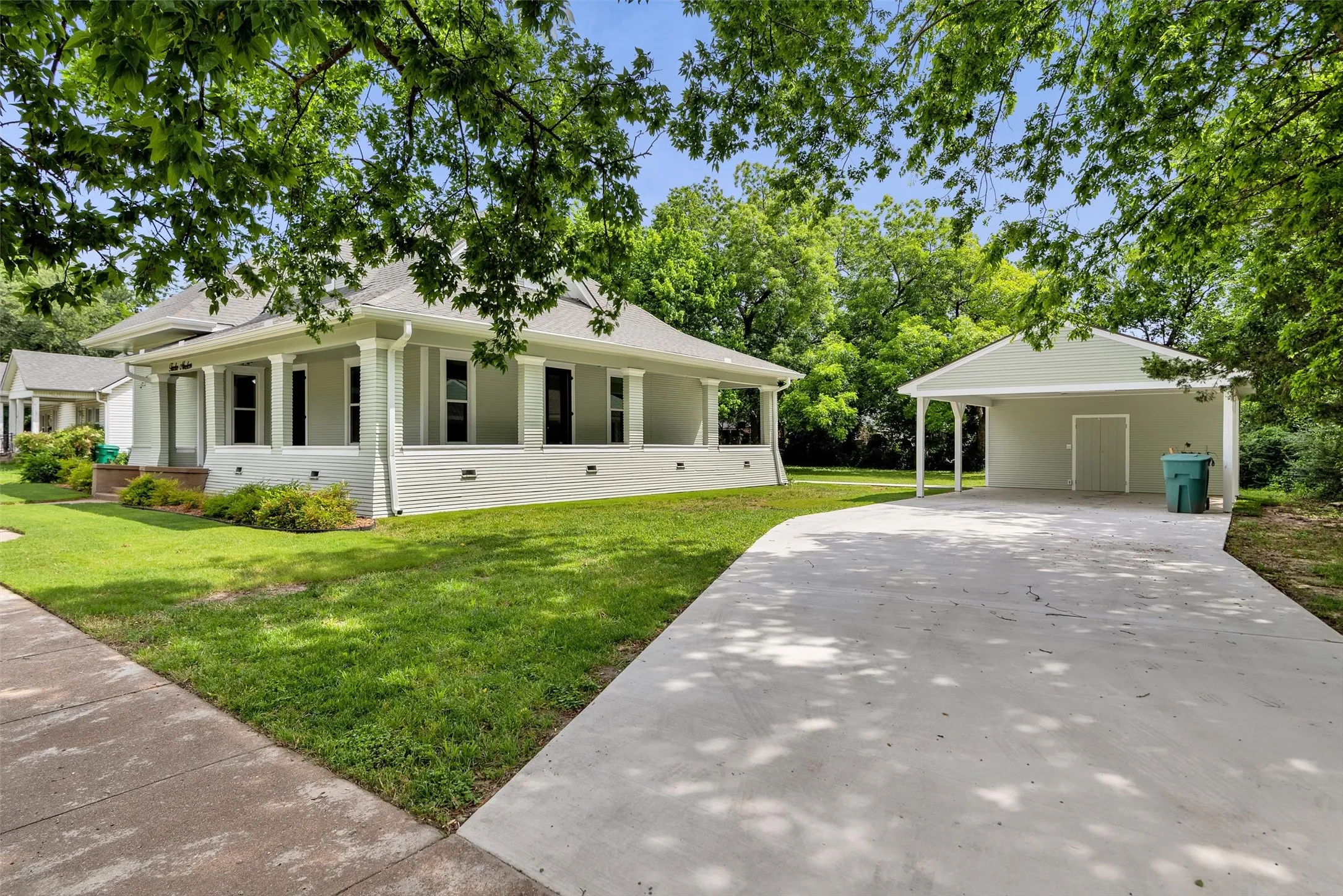 Cottage-style home with a covered front porch, light gray siding, and white trim