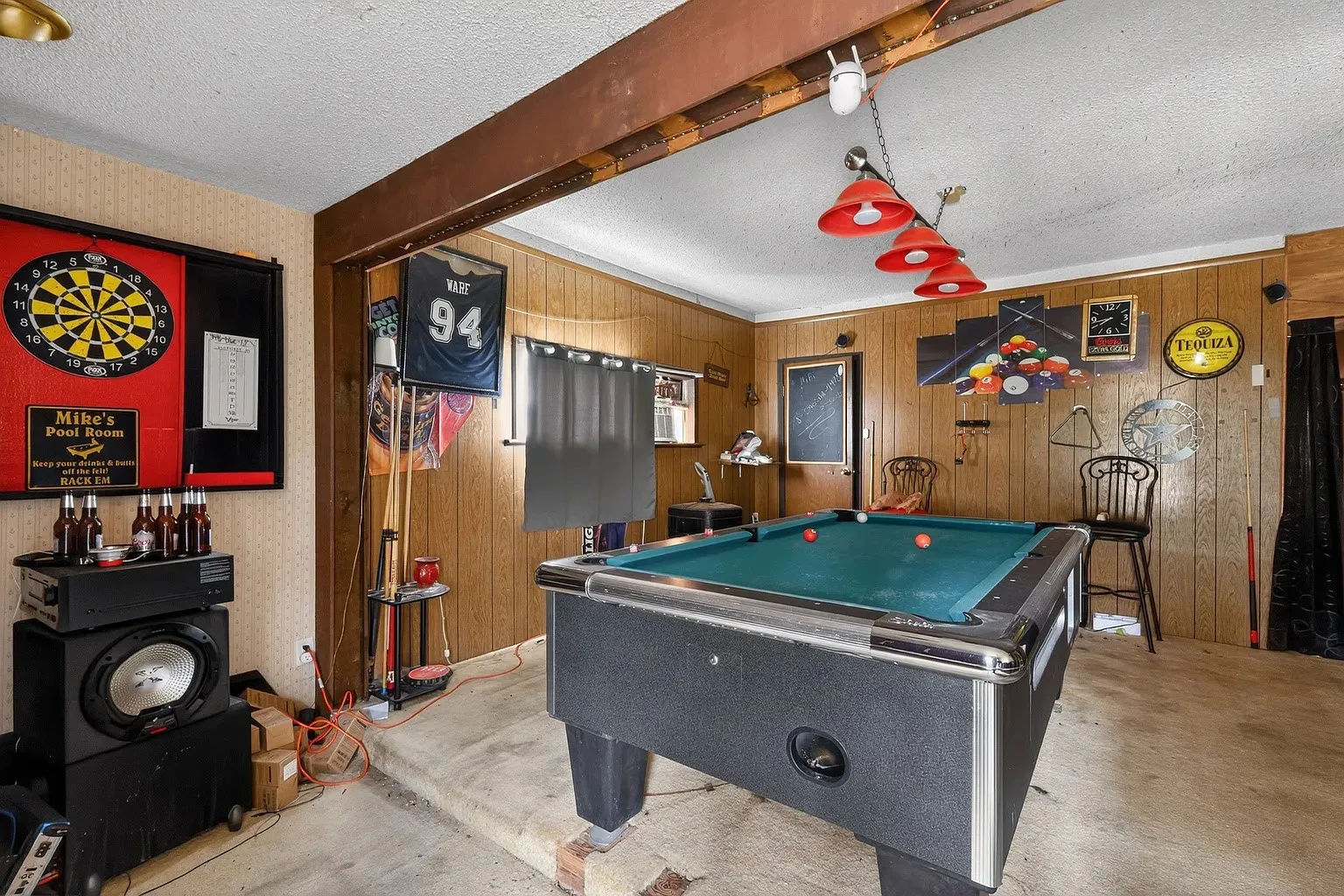 Recreation room featuring paneled walls, a built-in pool table, and overhead pendant lighting
