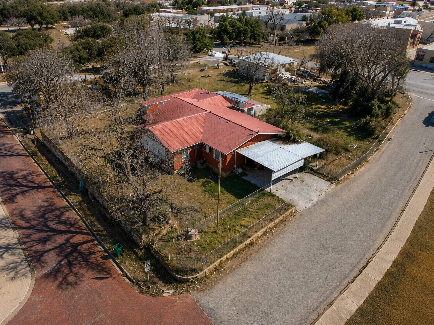 Elevated aerial view showing the single-story residence and the surrounding neighborhood.