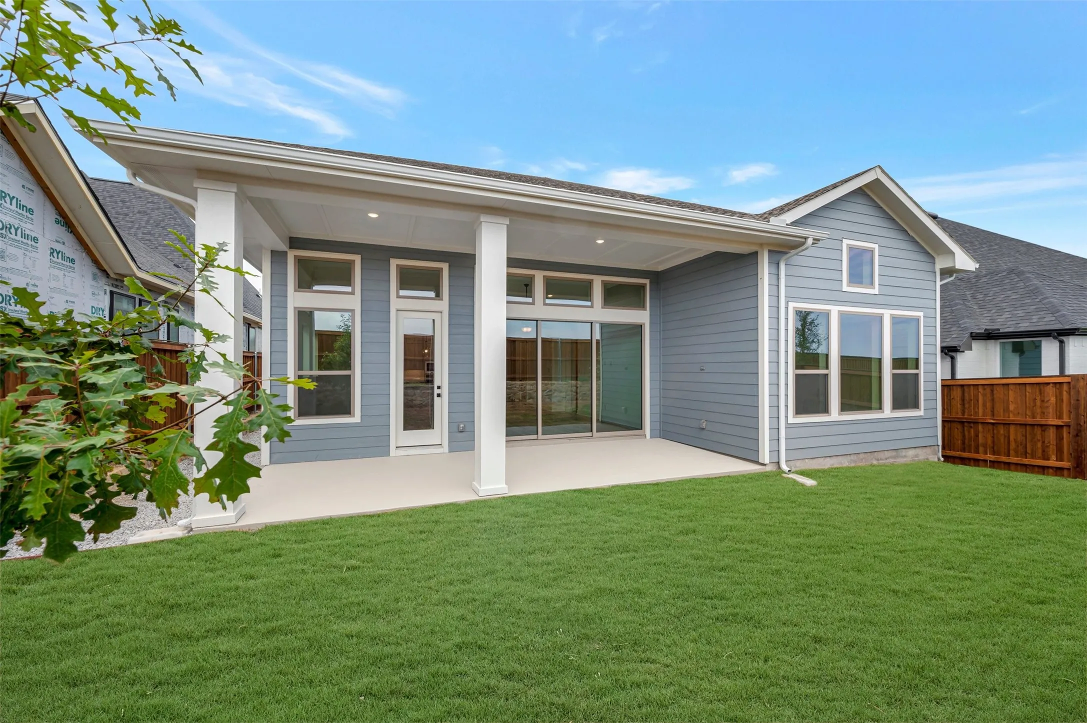 Expansive covered patio with recessed lighting, multiple large windows, and sliding glass door access