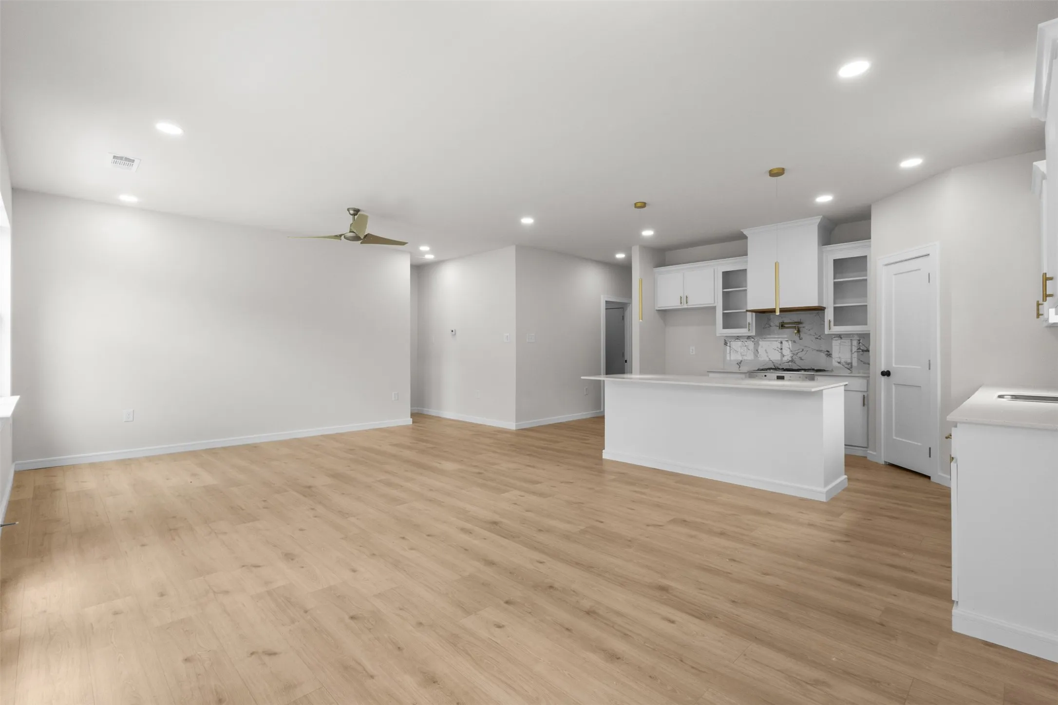 Open-concept living space featuring wood-finish flooring, recessed lighting, and a contemporary ceiling fan