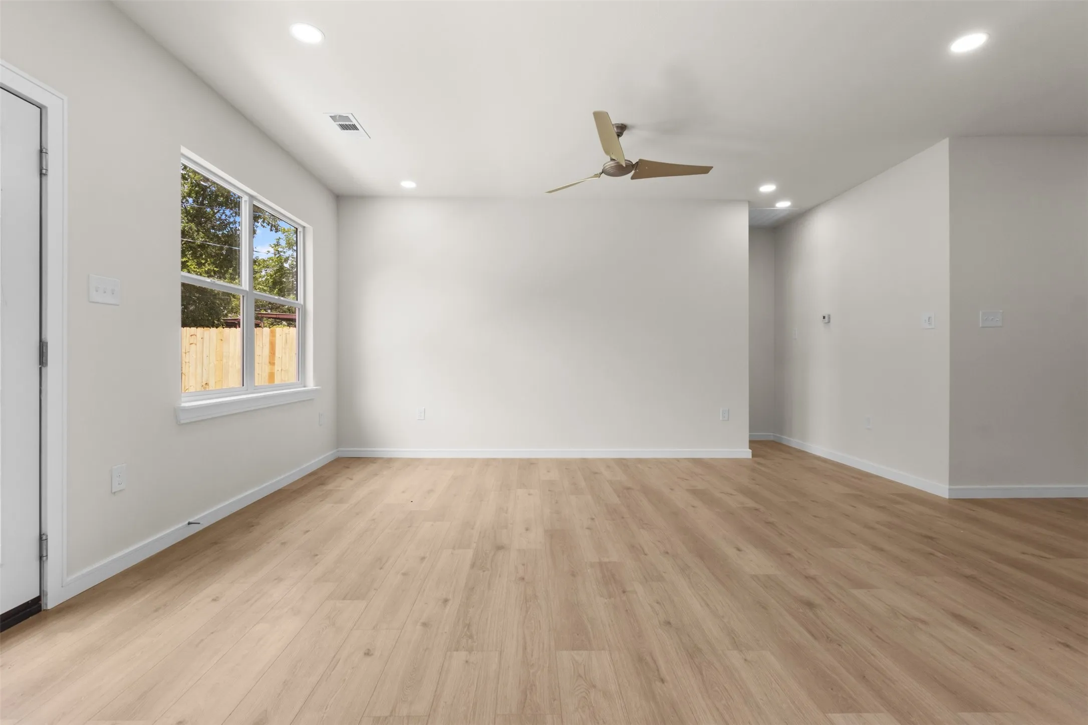 Open living space featuring wood-finish flooring, recessed lighting, and a ceiling fan
