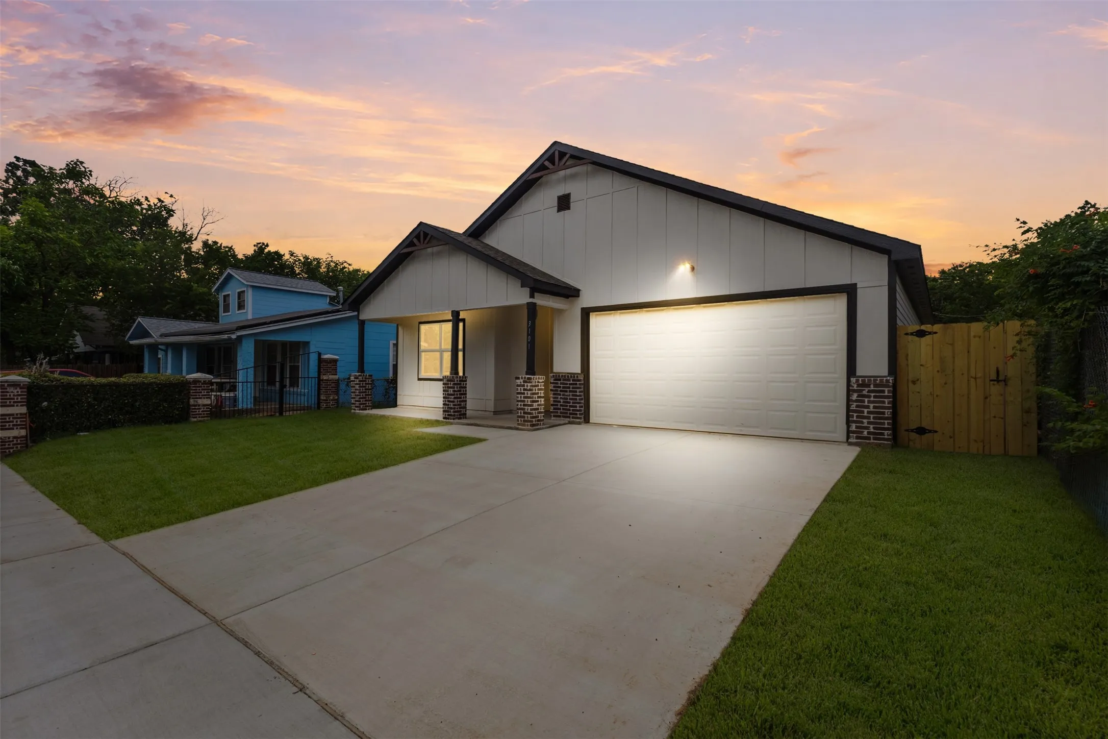 Modern farmhouse-style exterior with vertical siding, dark trim, a two-car garage, and a covered front entry