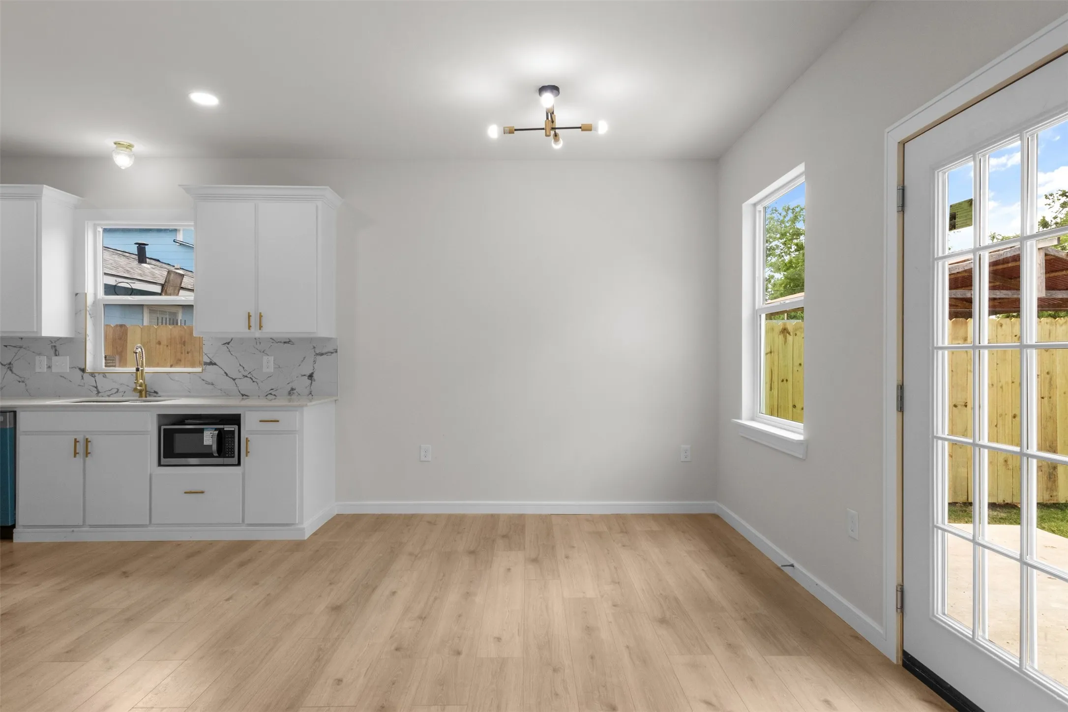 Open-concept area featuring light wood-finish flooring and white walls