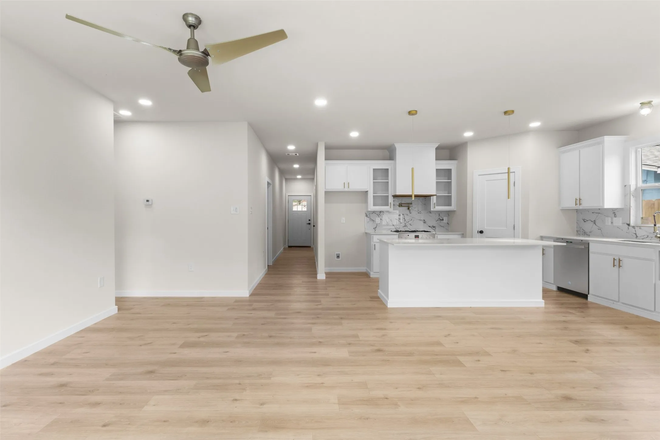 Open-concept living space featuring wood-finish flooring, recessed lighting, and a contemporary ceiling fan