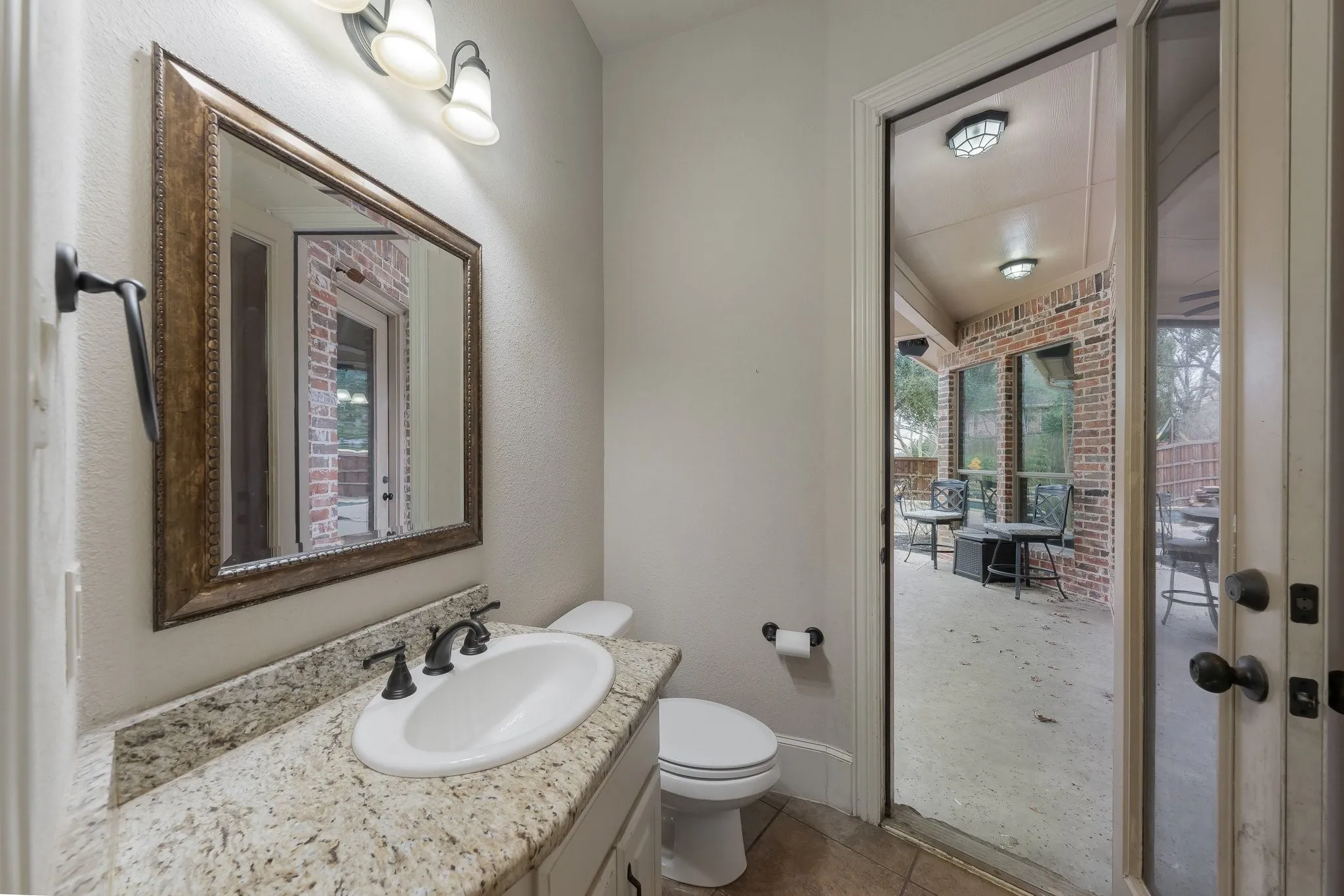 Vanity with a granite-style countertop, undermount sink, and oil-rubbed bronze faucet