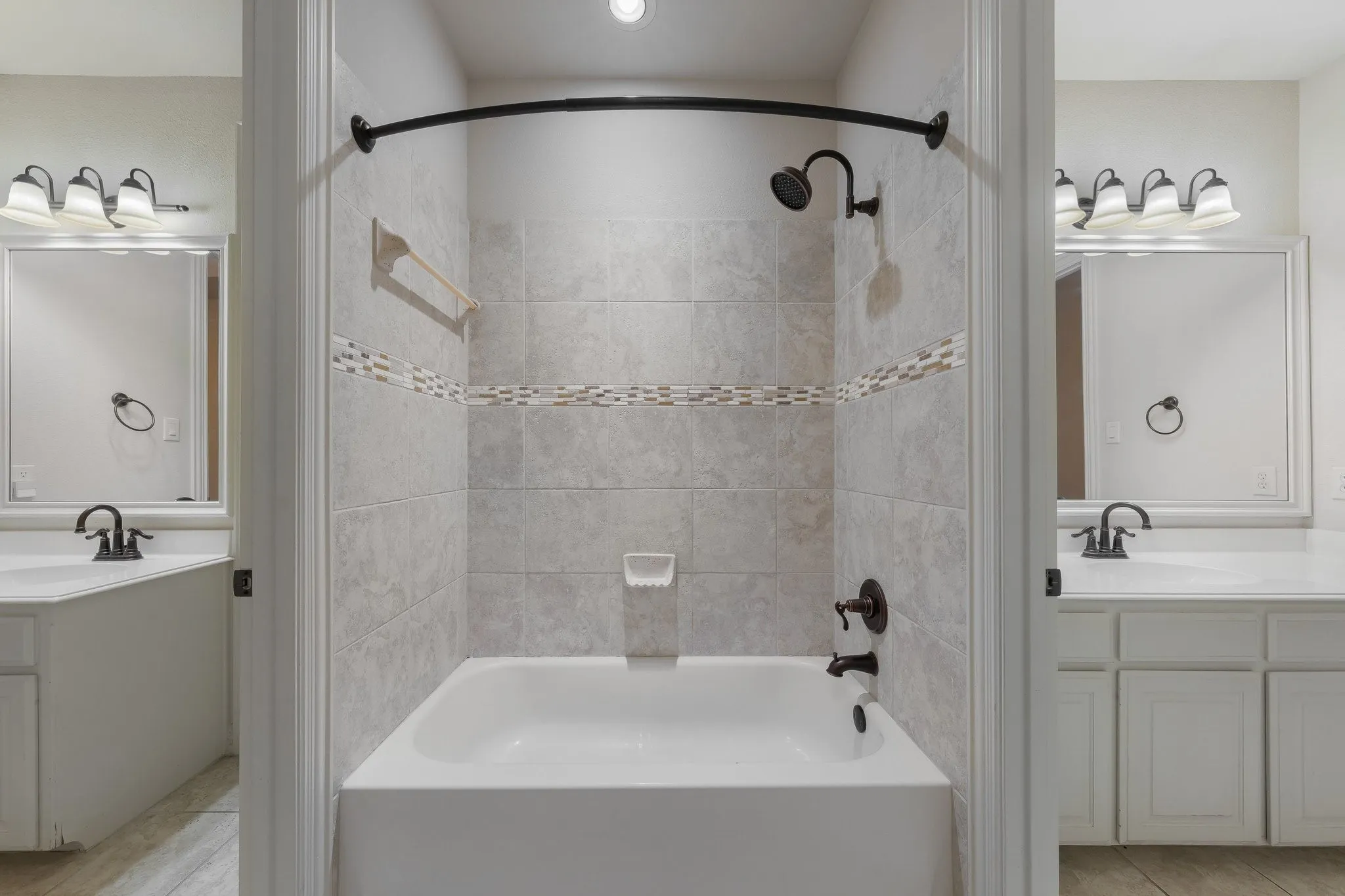 Tiled tub and shower combination featuring a decorative mosaic accent band