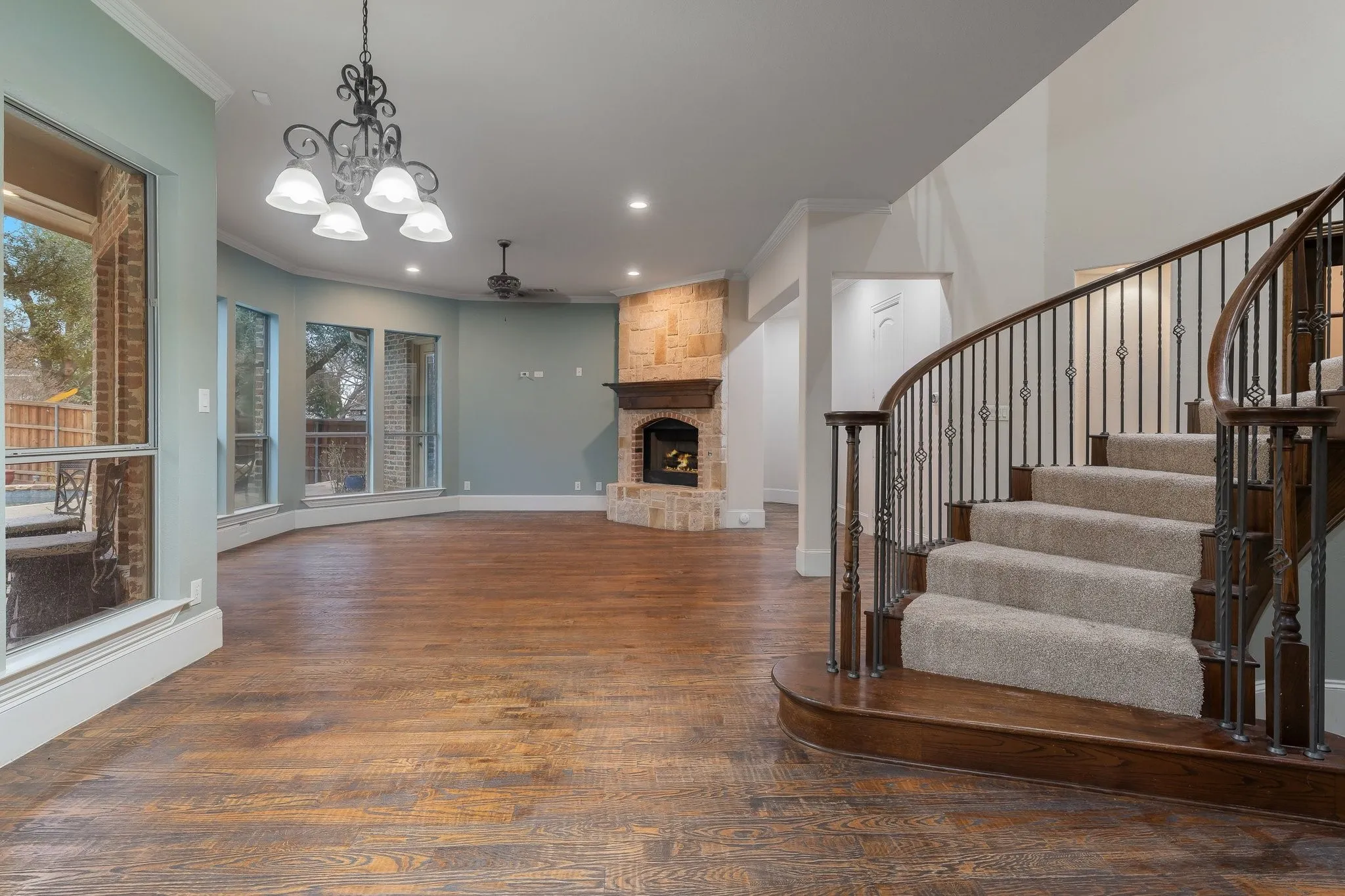 Curved staircase with wrought iron balusters and carpeted treads
