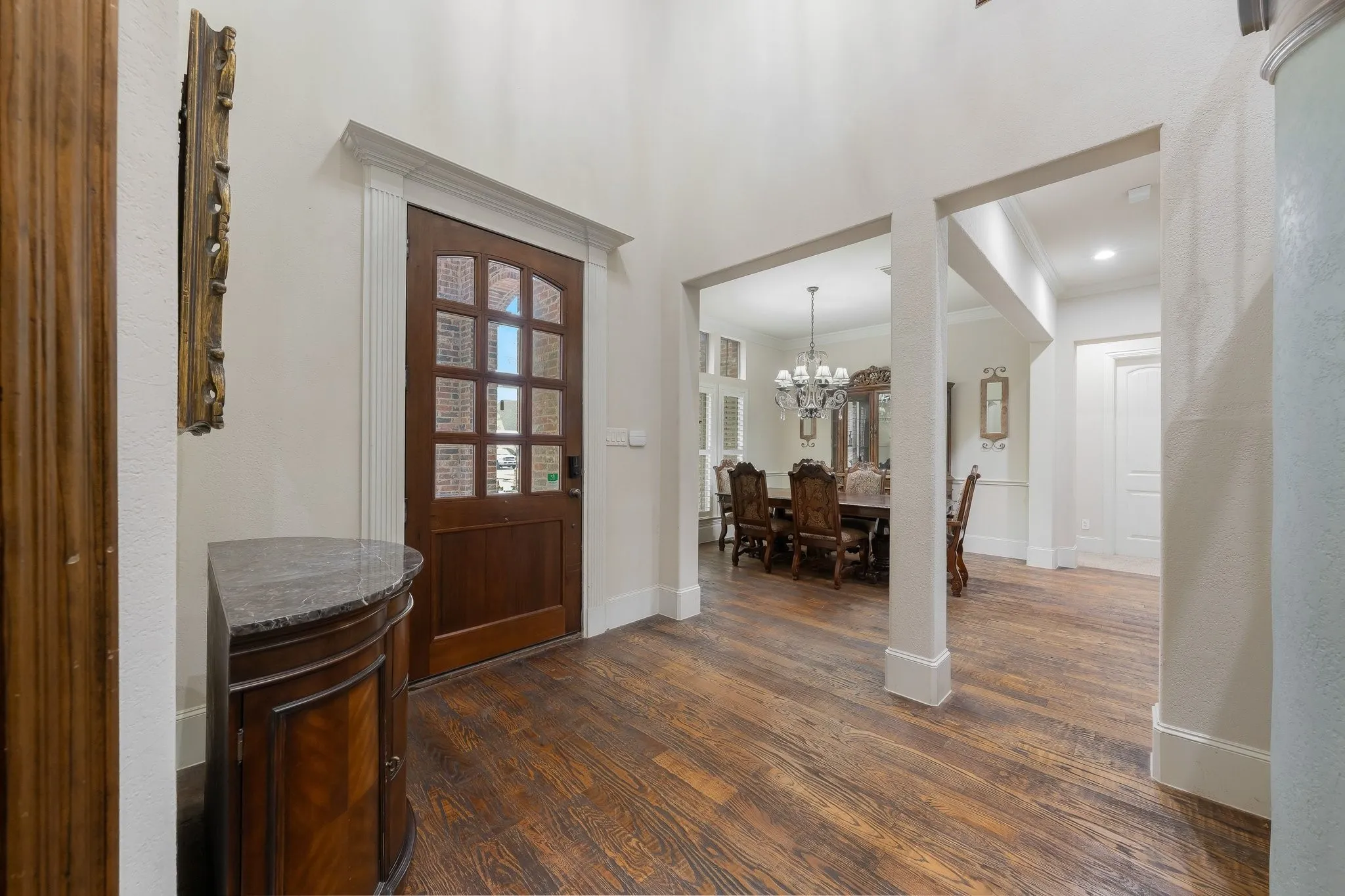 Foyer featuring wood-finish flooring, a solid wood entry door with divided lites, and an arched transom