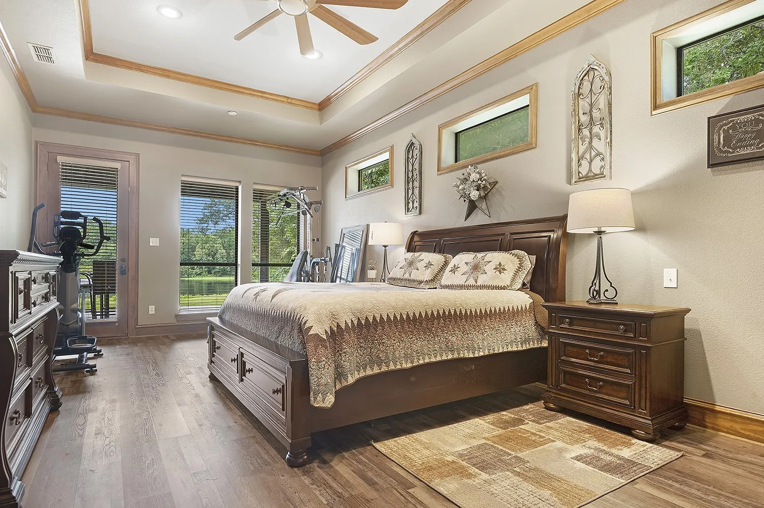 Spacious interior featuring wood-finish flooring, a tray ceiling with recessed lighting and a ceiling fan, and multiple windows