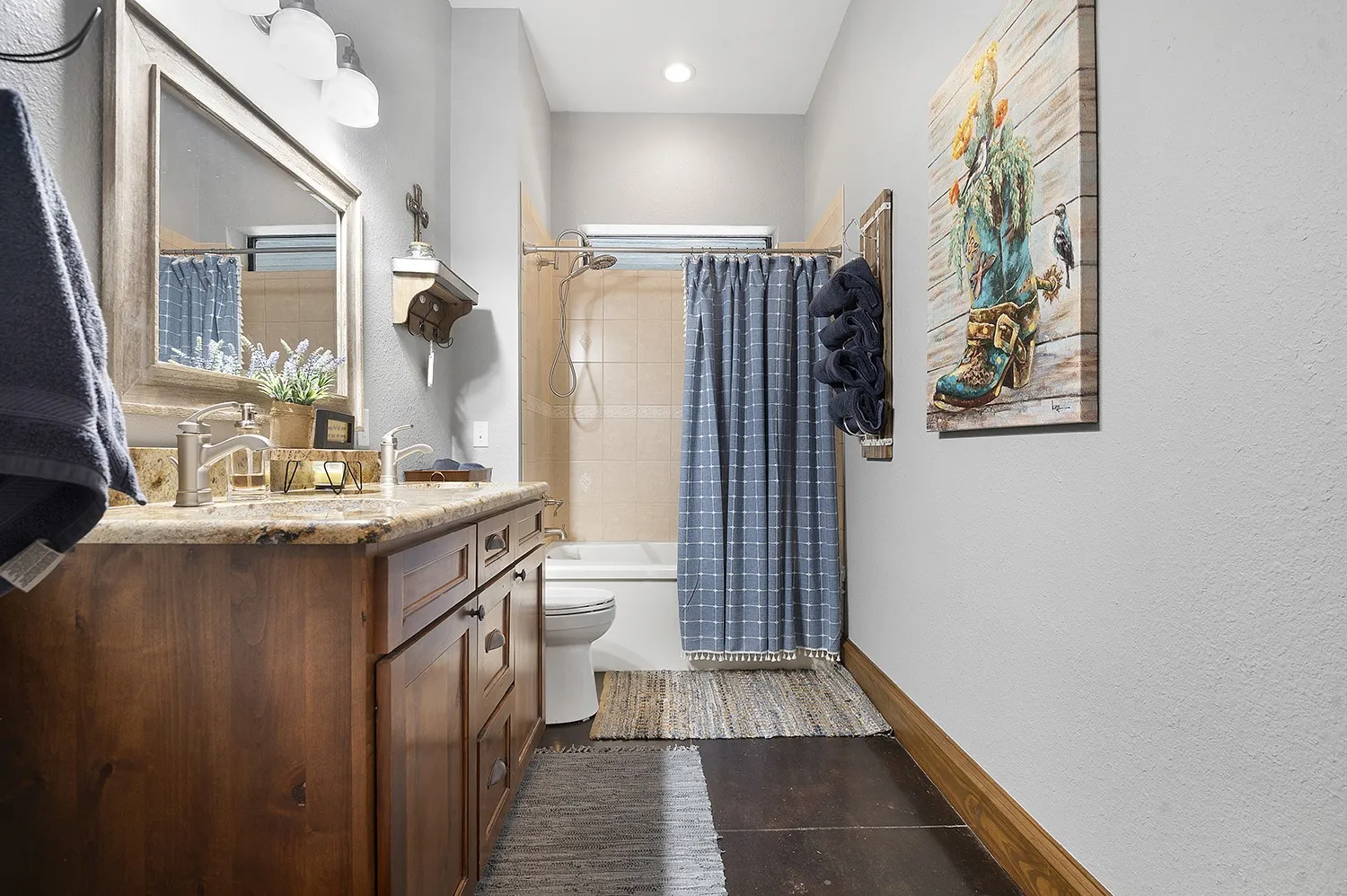 Bathroom featuring a wood-finish vanity with a stone countertop, dual undermount sinks, and brushed nickel fixtures