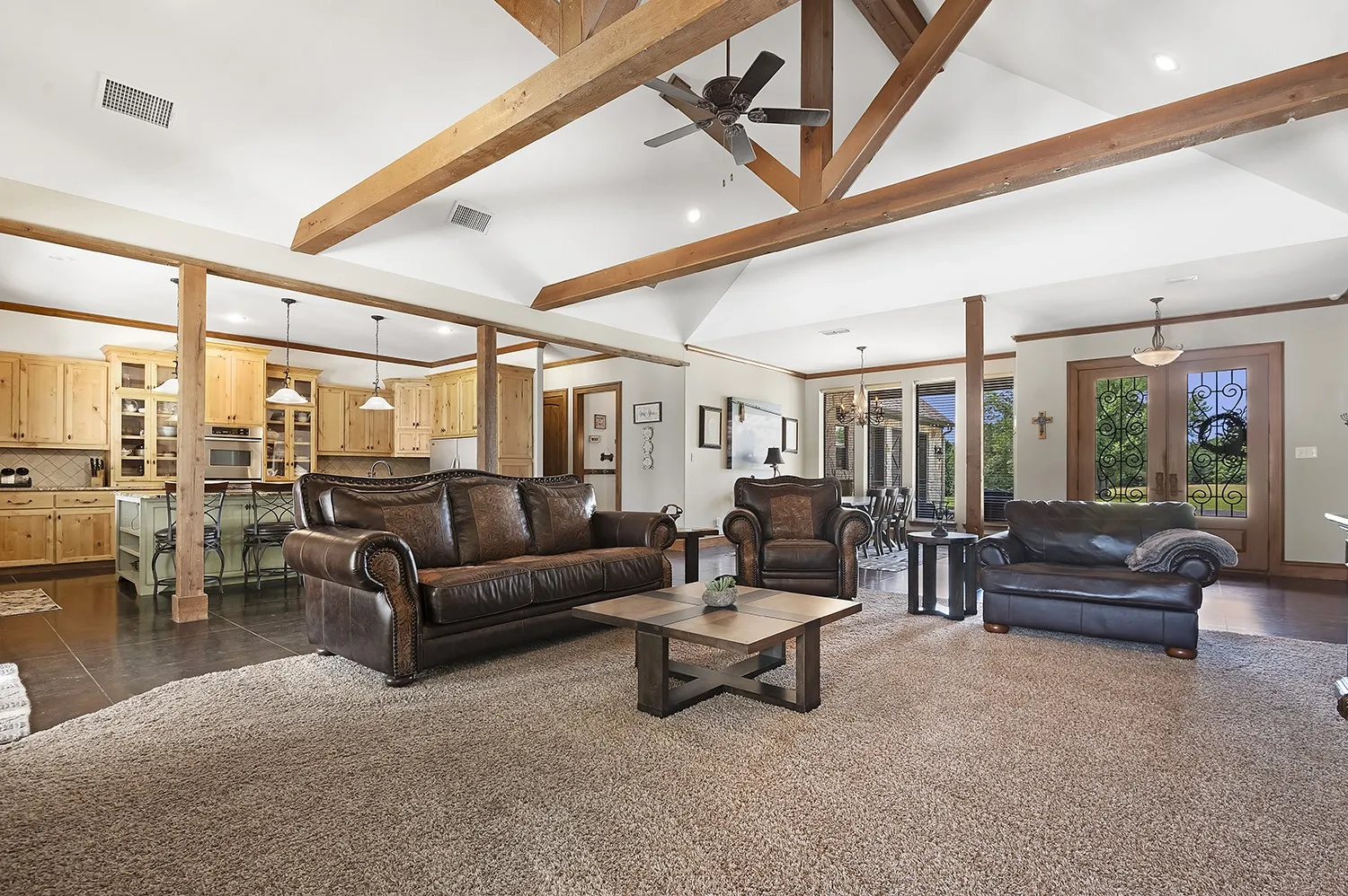 Spacious living area featuring exposed wood beam vaulted ceilings and plush carpeting
