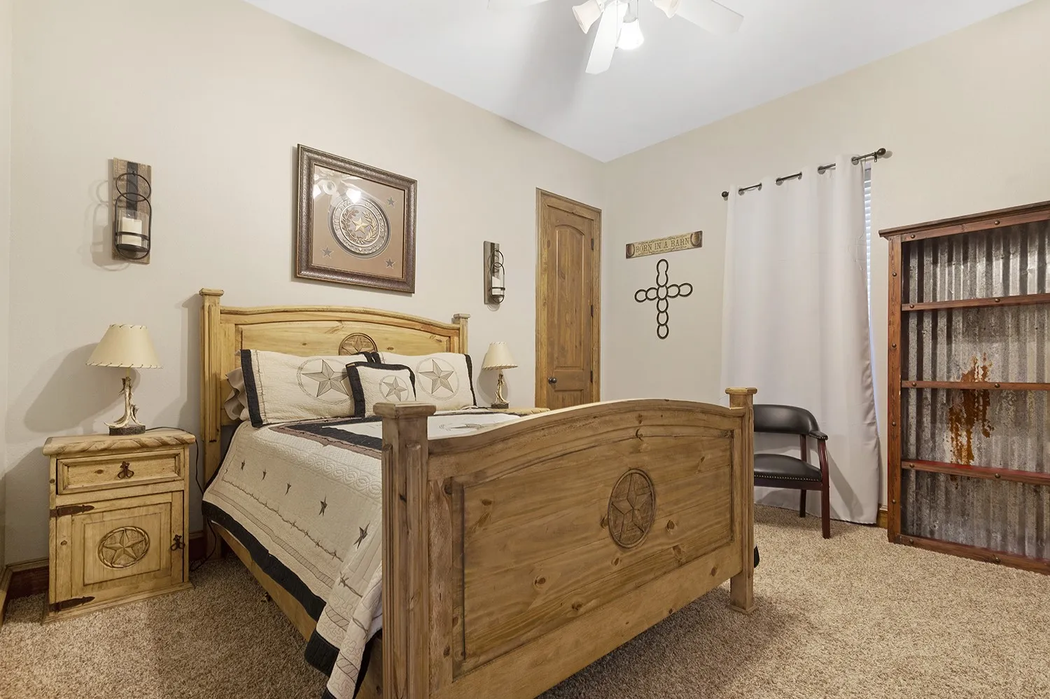 Carpeted room featuring a light wood-finish bed frame, matching nightstand, and a built-in ceiling fan