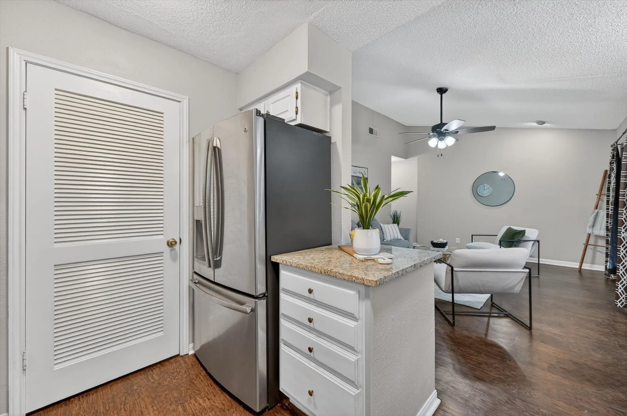 Kitchenette featuring a granite-look countertop and white cabinetry with drawer pulls