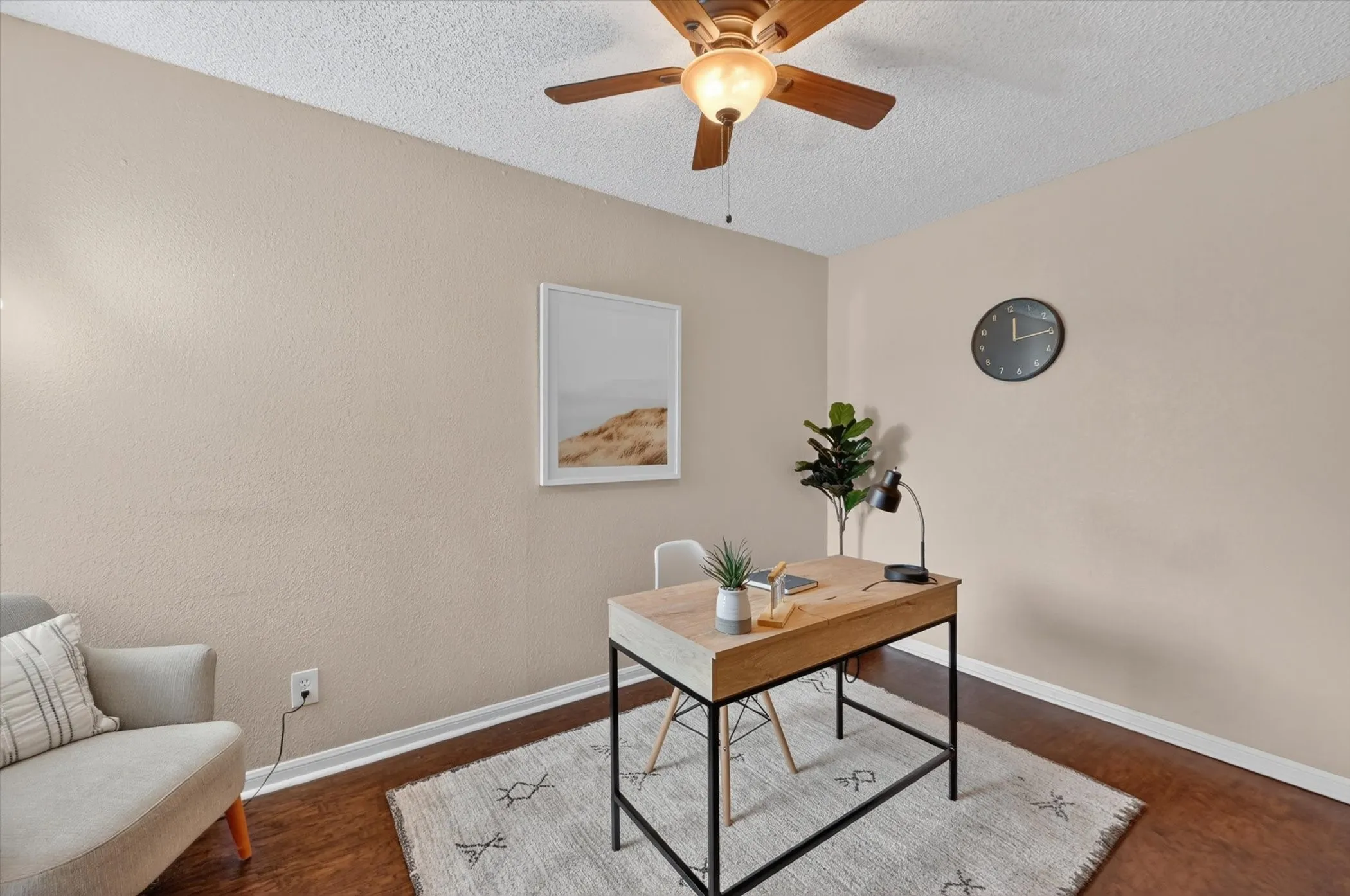 Versatile room featuring wood-finish flooring, a ceiling fan with integrated lighting, and neutral wall tones