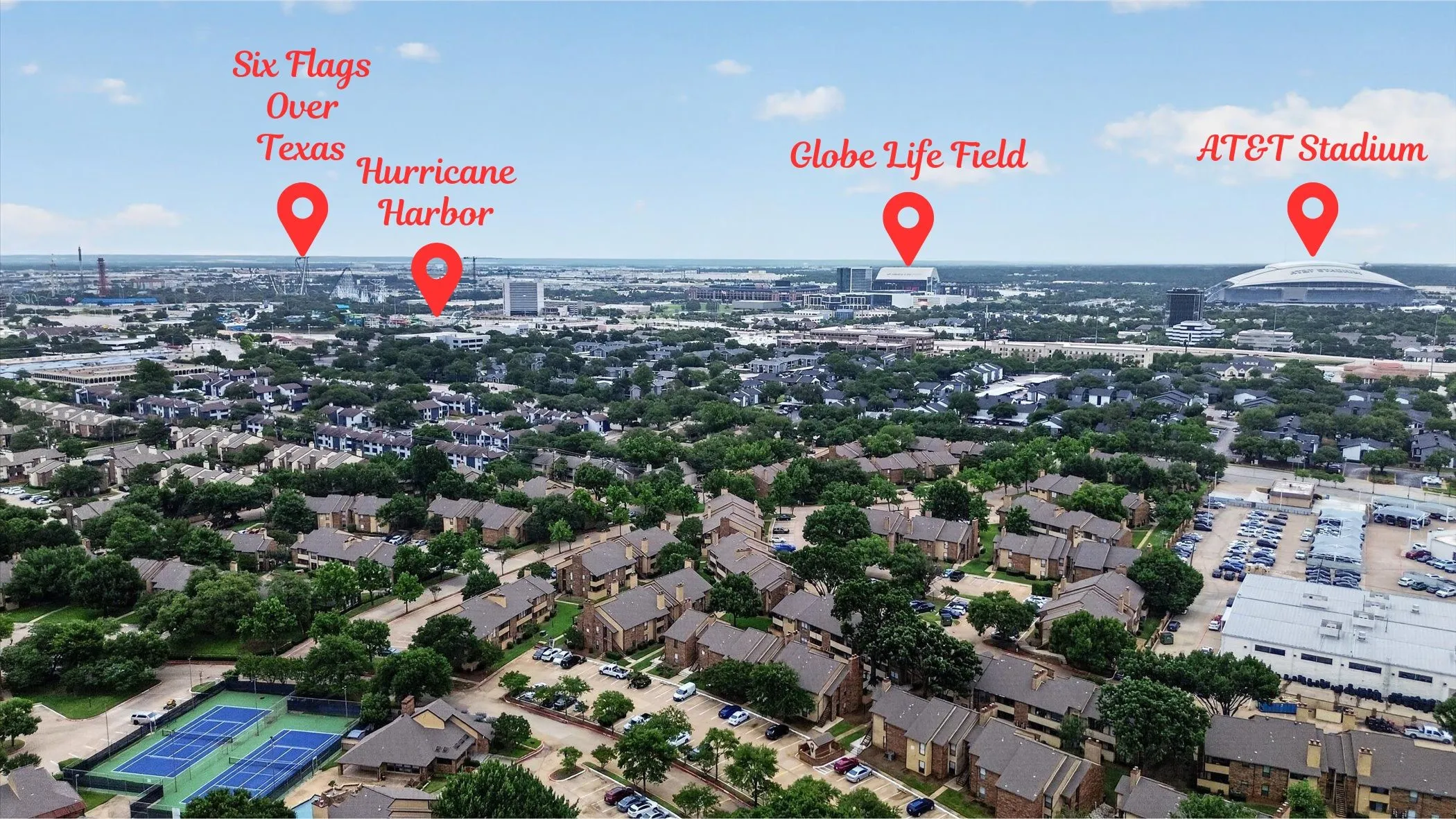 Aerial perspective showcasing extensive urban development with a prominent sports complex and multiple amusement park structures in the distance