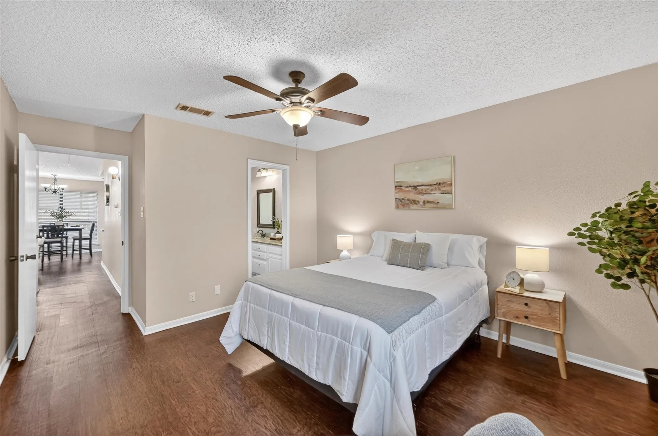 Bedroom featuring wood-finish flooring, a ceiling fan with integrated lighting, and neutral wall tones