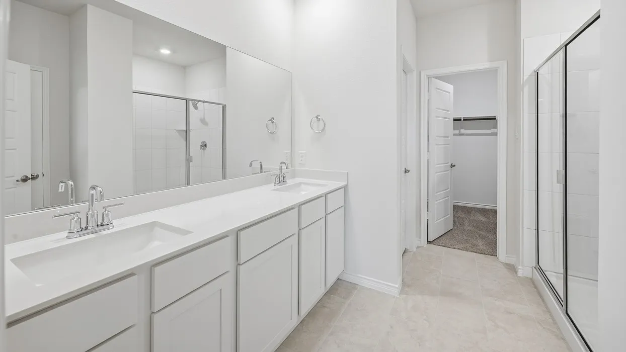 Contemporary bathroom featuring a double vanity with integrated sinks, chrome fixtures, and an expansive mirror