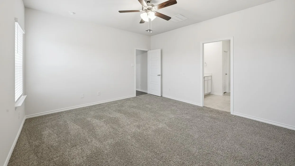 Spacious carpeted room featuring a ceiling fan with light fixture, a window with blinds, and white paneled doors