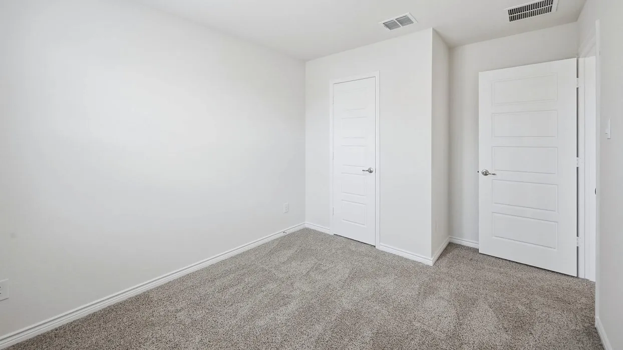 Carpeted room featuring white walls, white baseboards, and two white paneled doors with silver hardware