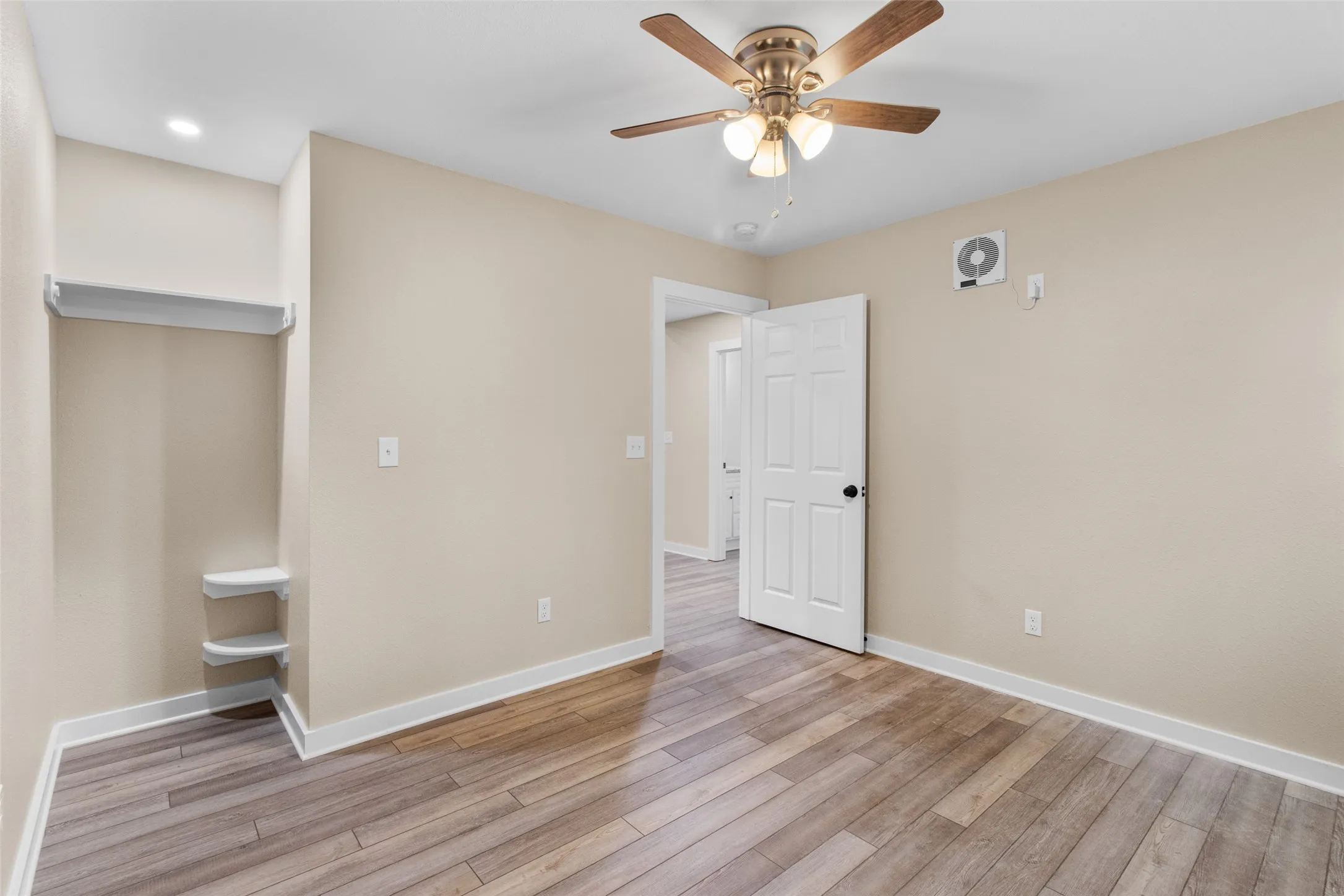 Interior room featuring wood-finish flooring and neutral wall tones