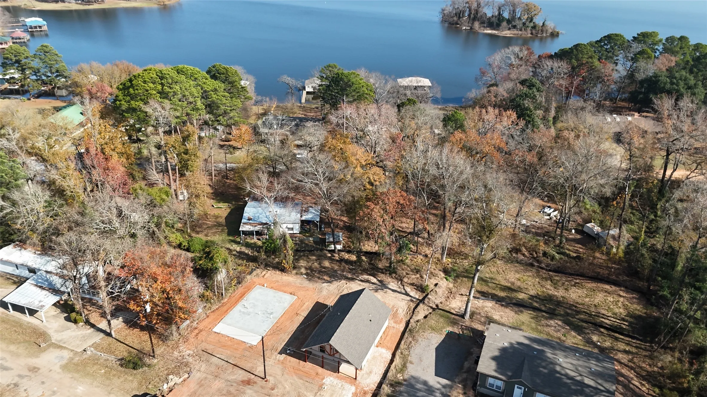 Expansive waterfront property featuring a substantial lakefront, mature tree coverage, and an adjacent building site