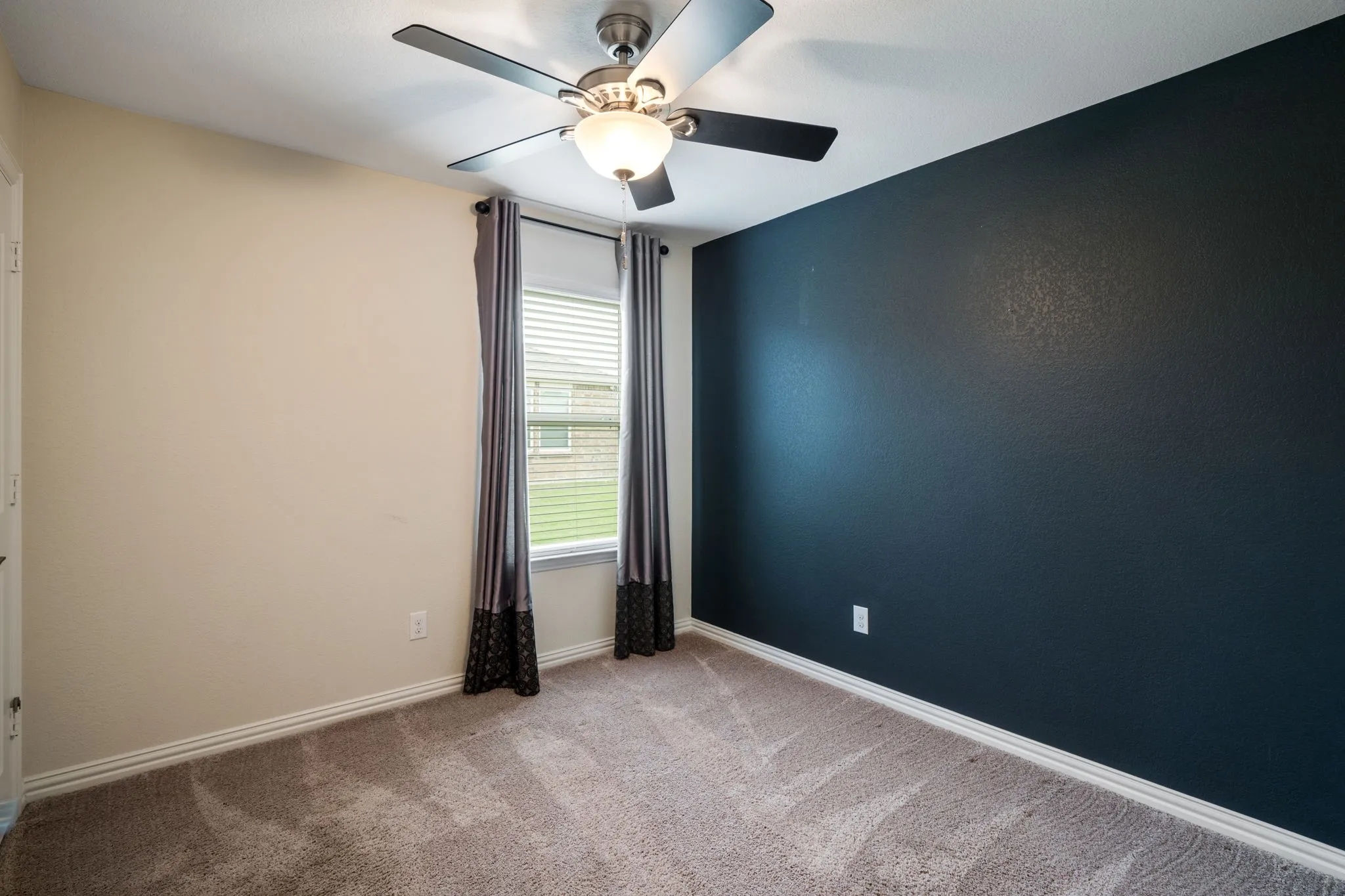 Bedroom 2 with accent wall & ceiling fan.
