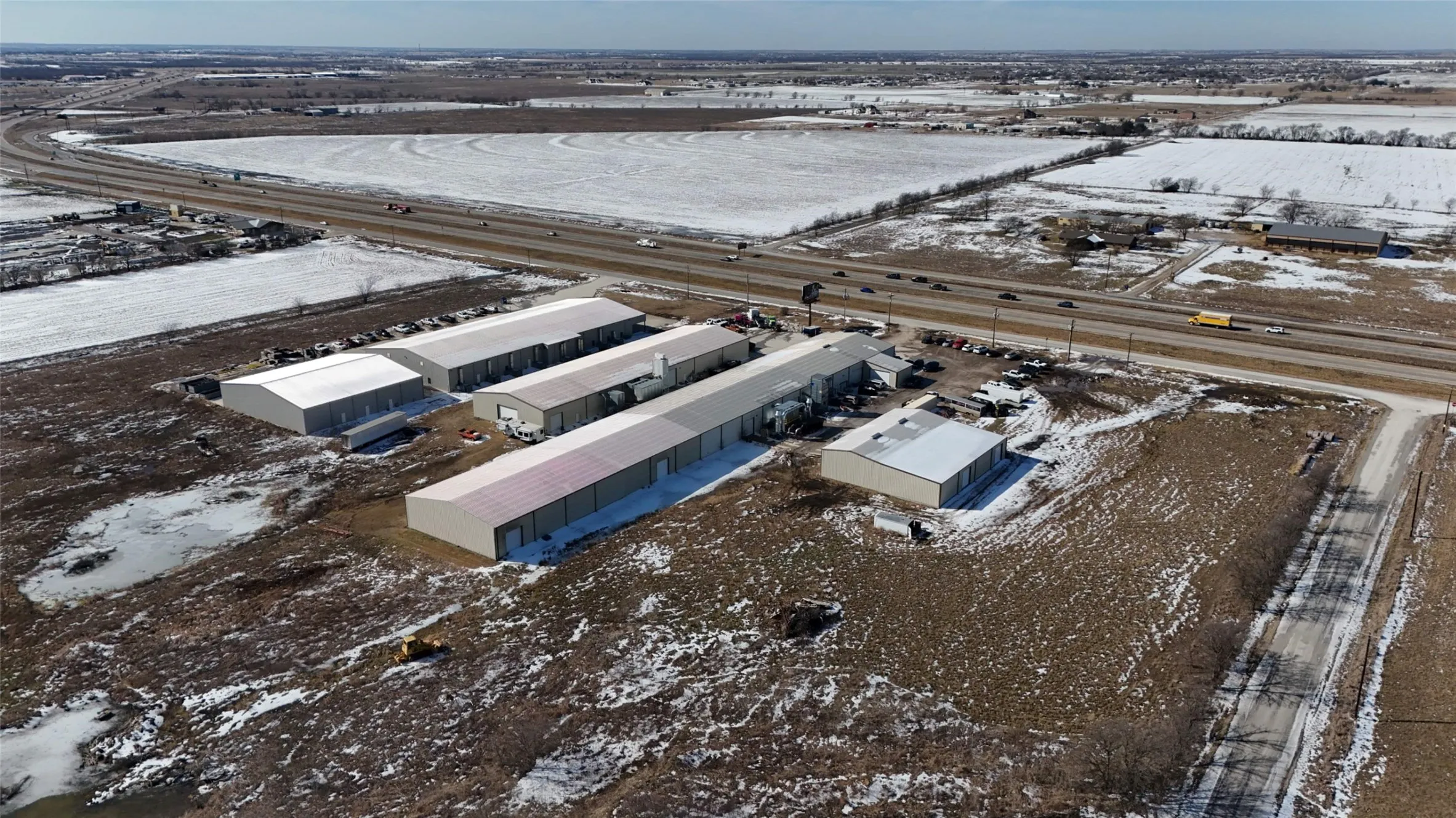 Industrial property featuring multiple metal buildings with pitched roofs